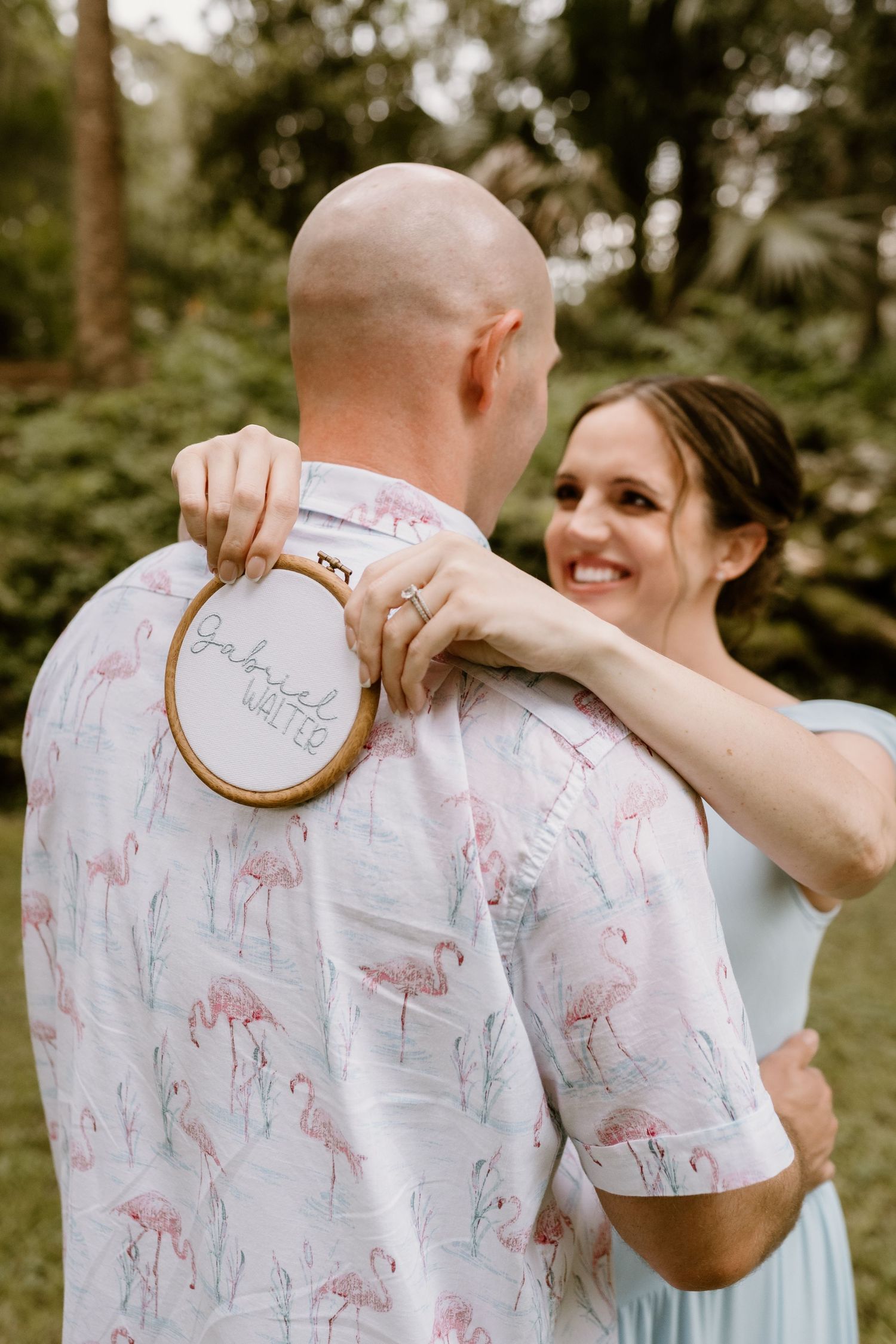 Couple shares intimate moment with embroidery hoop during outdoor photo session.