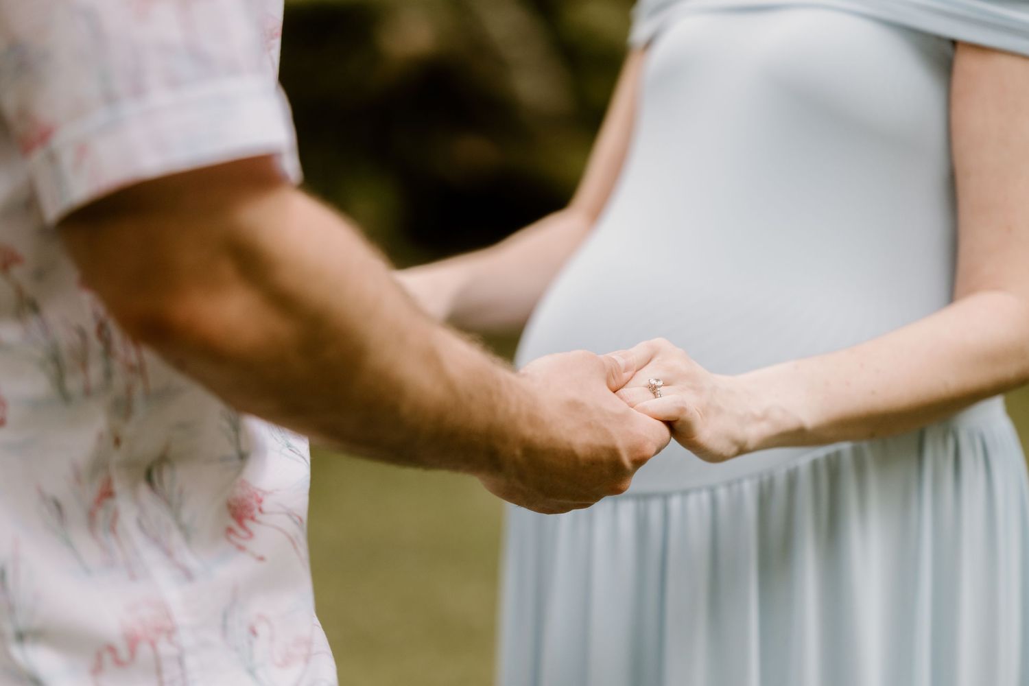 Intimate close-up of hands touching in formal wedding attire.