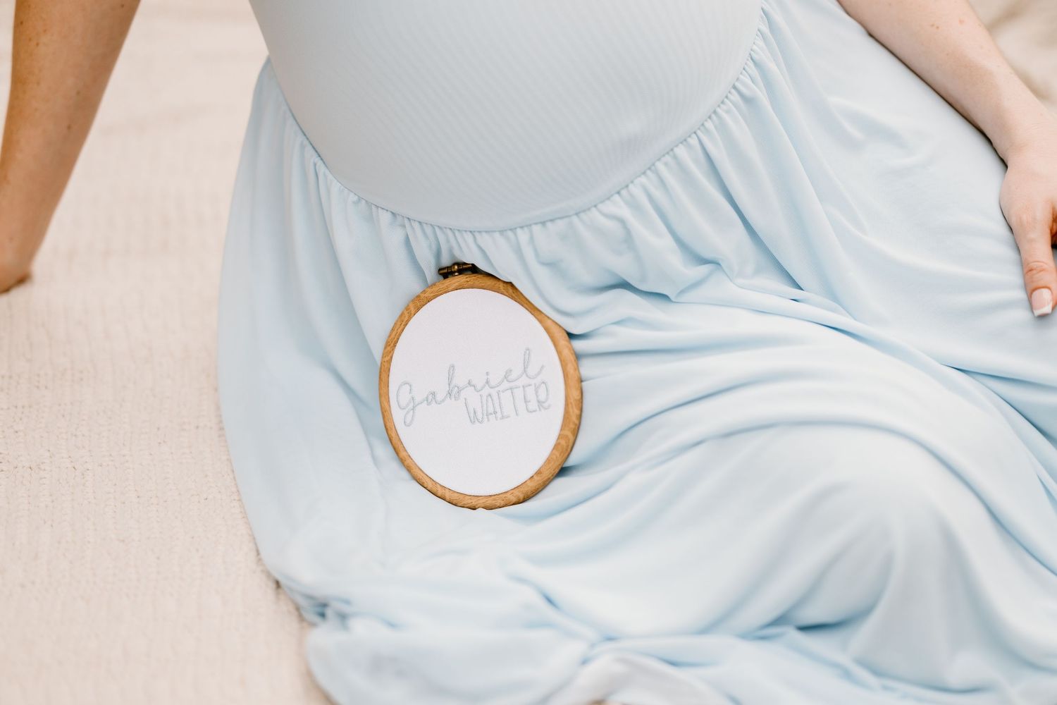 Close-up detail shot of light blue fabric with circular wooden object.