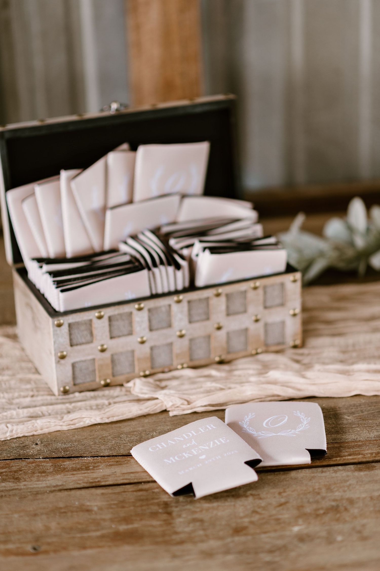 Wedding invitation envelopes arranged in a row on a rustic wooden table.