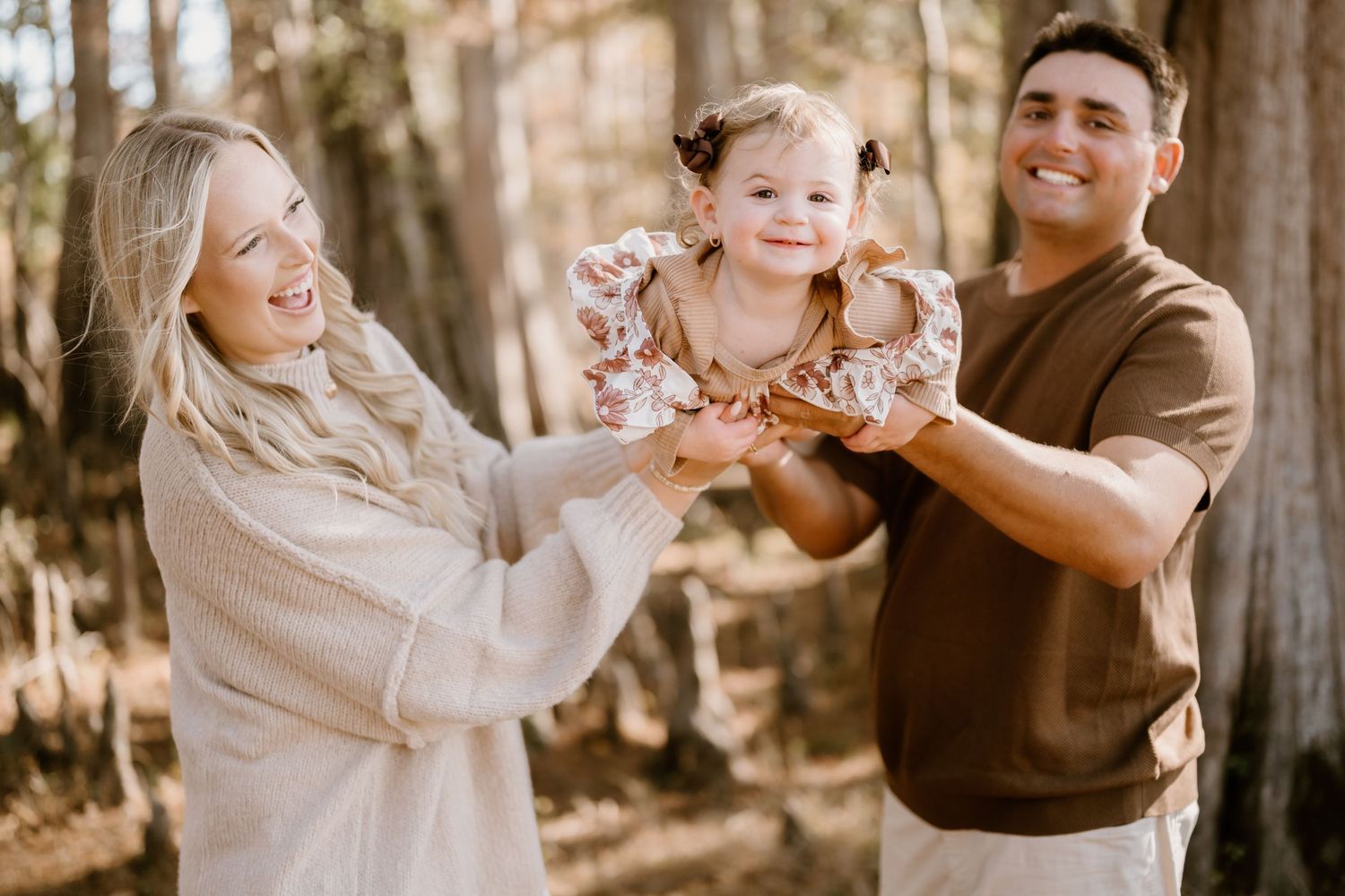 A happy family enjoying a warm autumn day together in a sunlit forest setting.