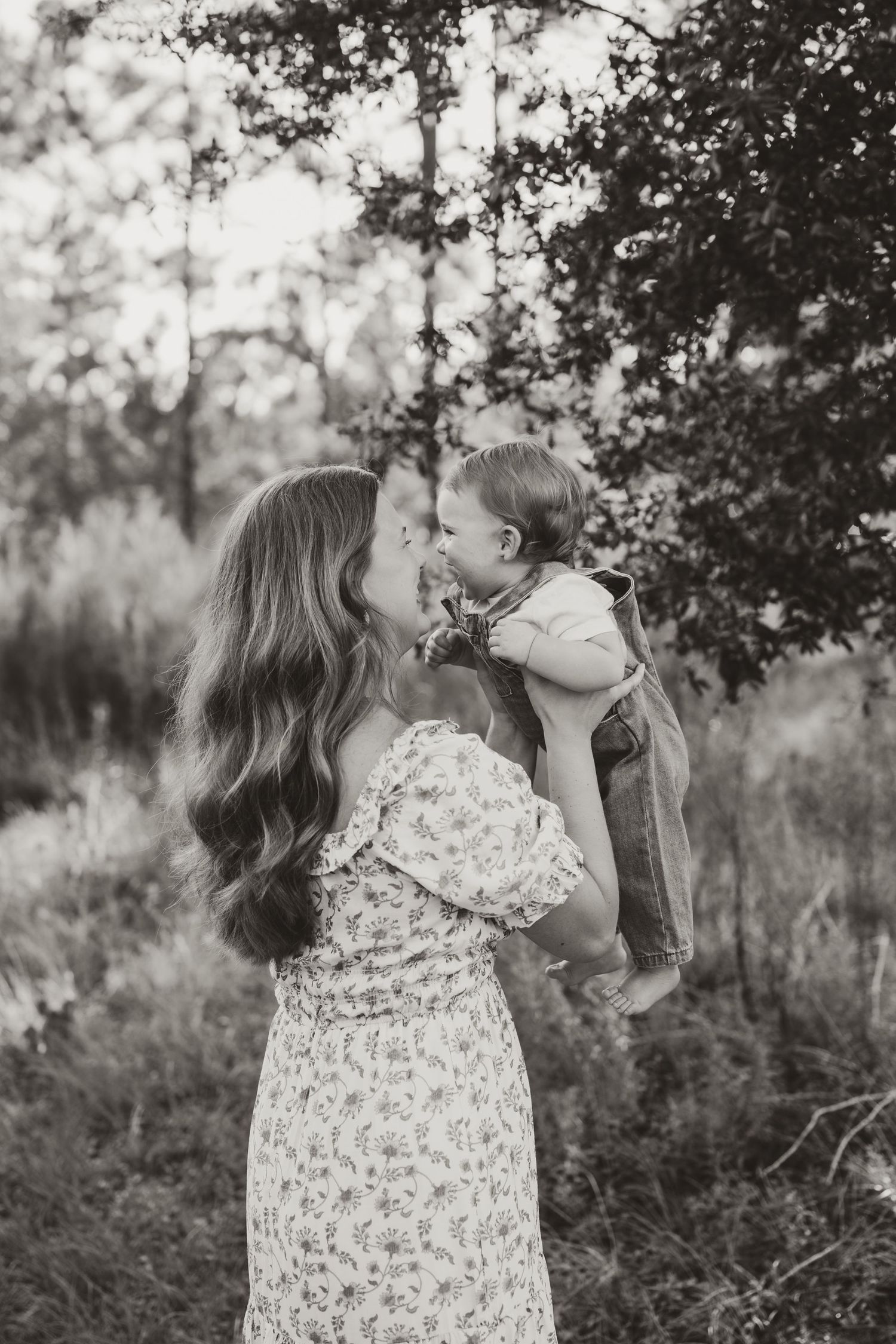A mother and child share tender moments in a natural outdoor setting.