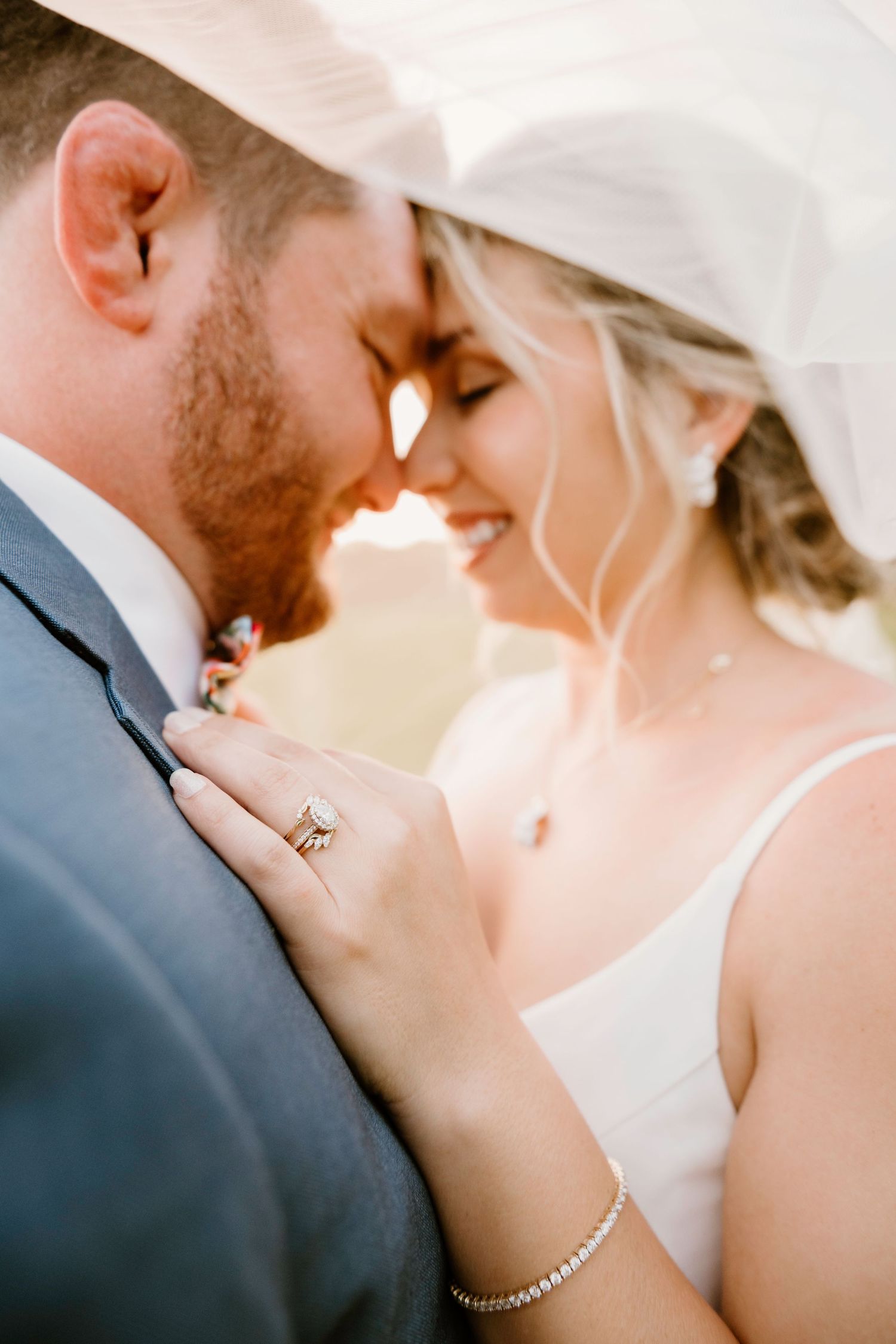 Close-up romantic wedding photos showing tender moments between a couple in formal attire with soft lighting.