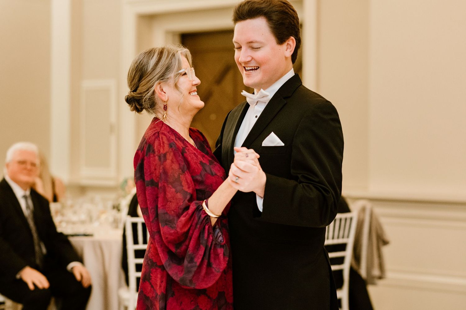 Wedding reception guests dancing and celebrating in an elegant ballroom.