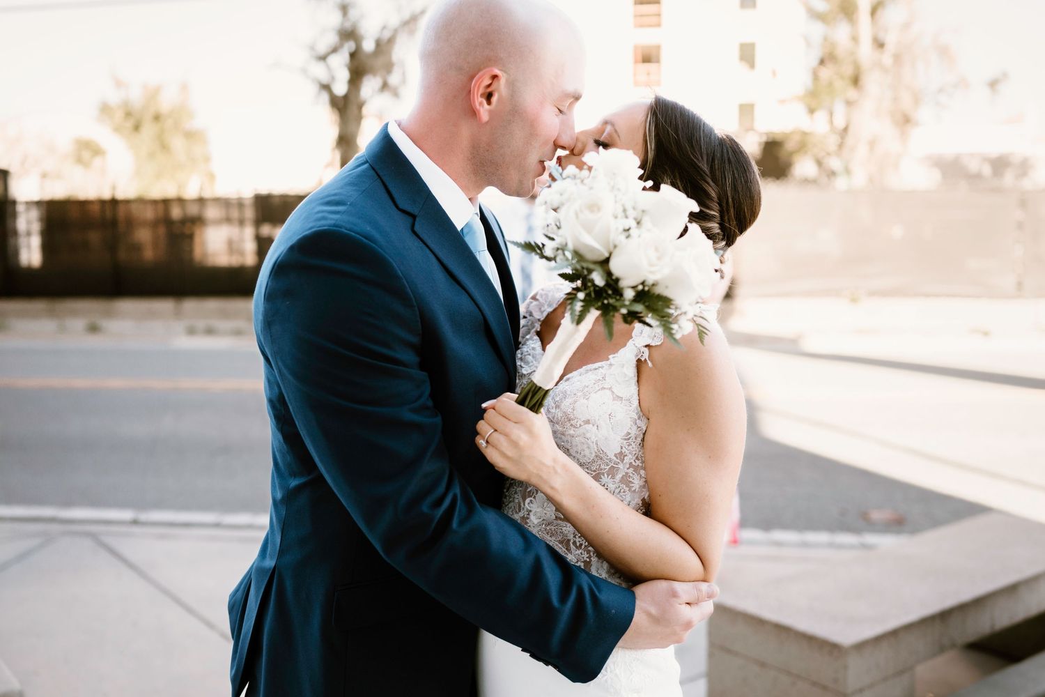Romantic wedding portraits captured outside a contemporary building at sunset.