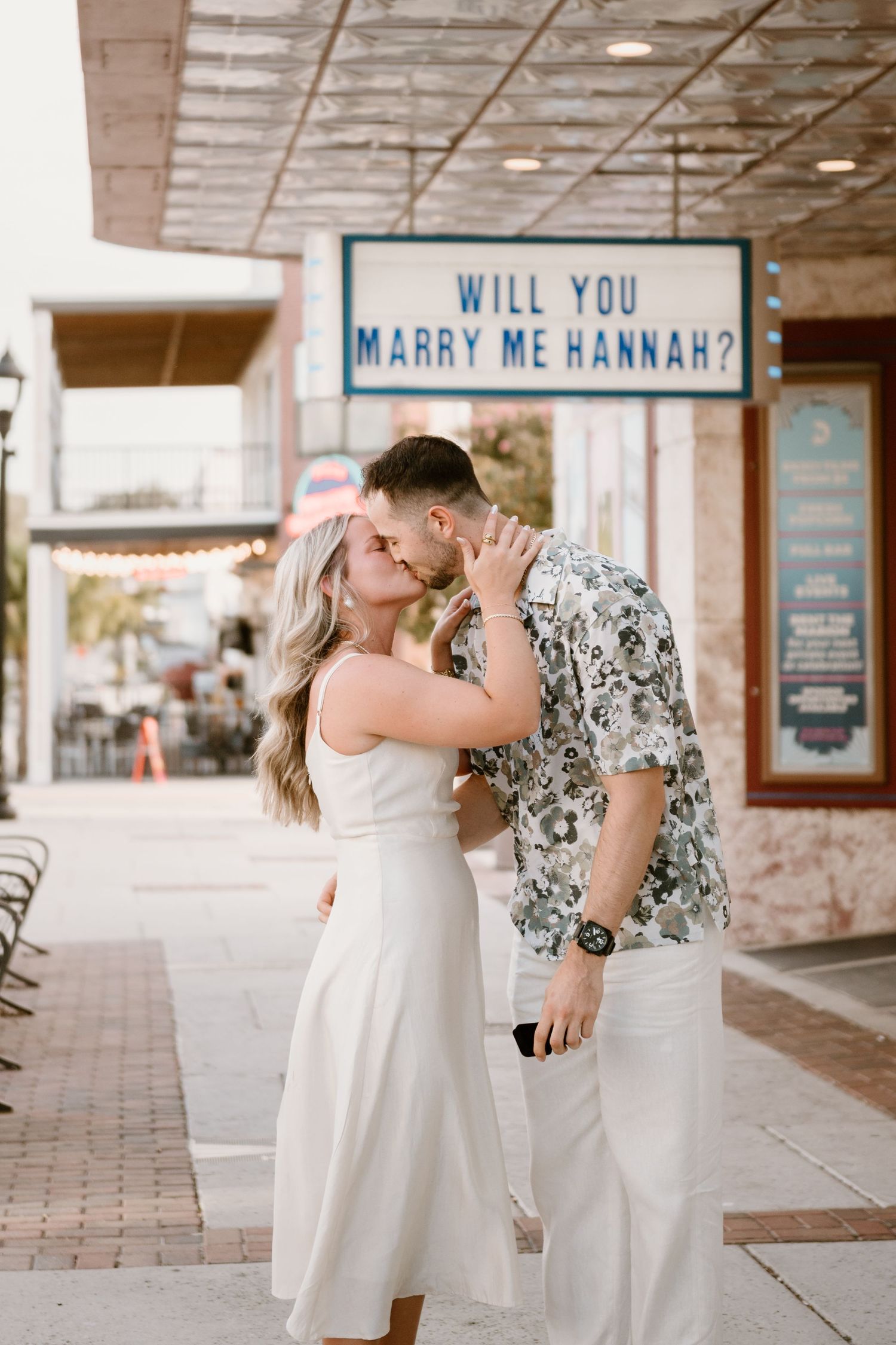 A couple shares a romantic moment during a surprise proposal at a vintage theatre.