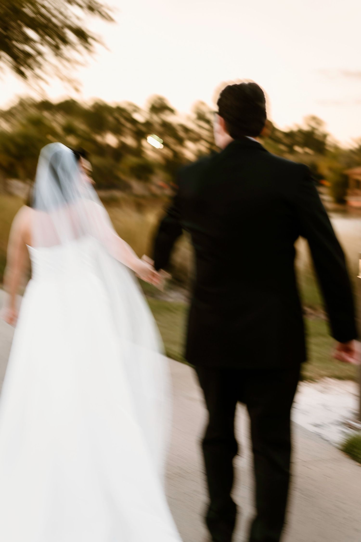 Artistic motion blur captures a couple walking together on their wedding day.