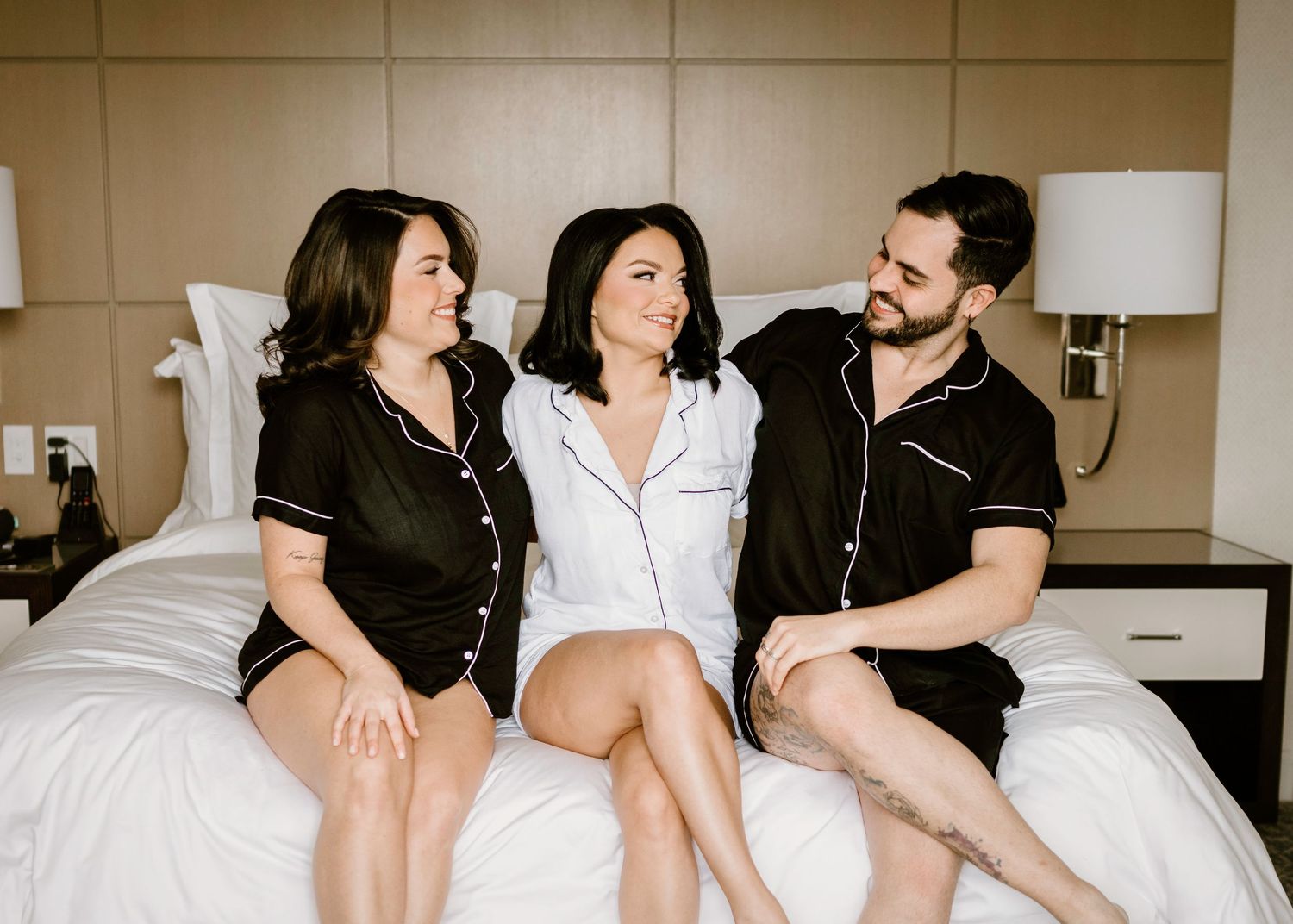 Friends relaxing together on a bed in casual loungewear during an intimate gathering.