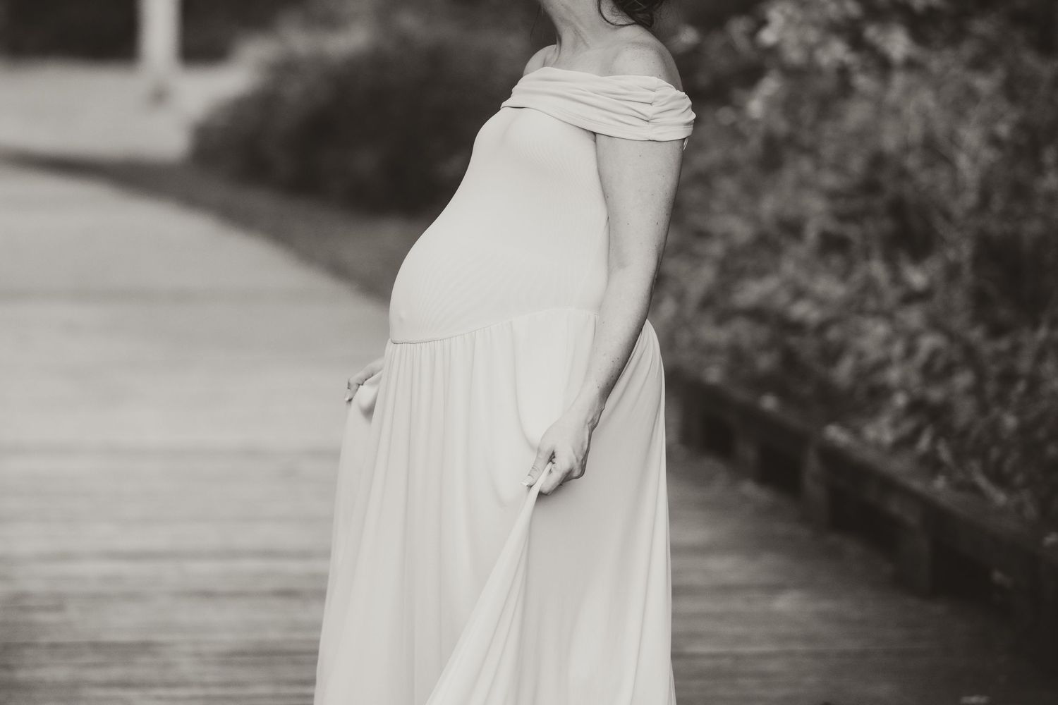 A flowing white dress captured in elegant motion against a dark natural background.