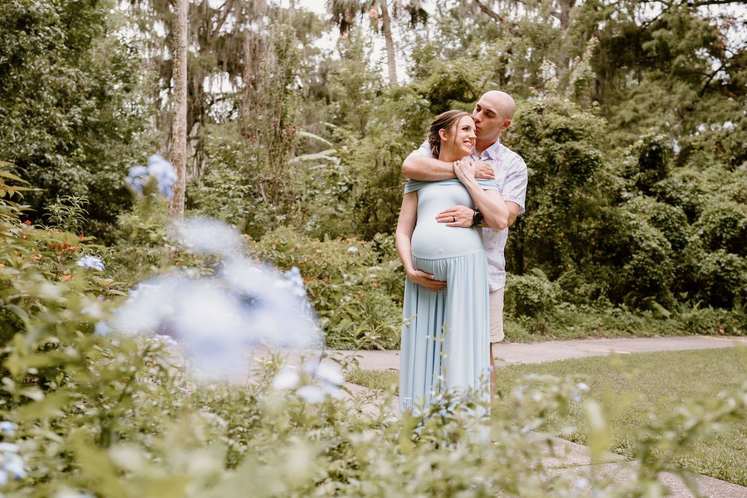 Candid outdoor family photography session in a park with trees and natural lighting.