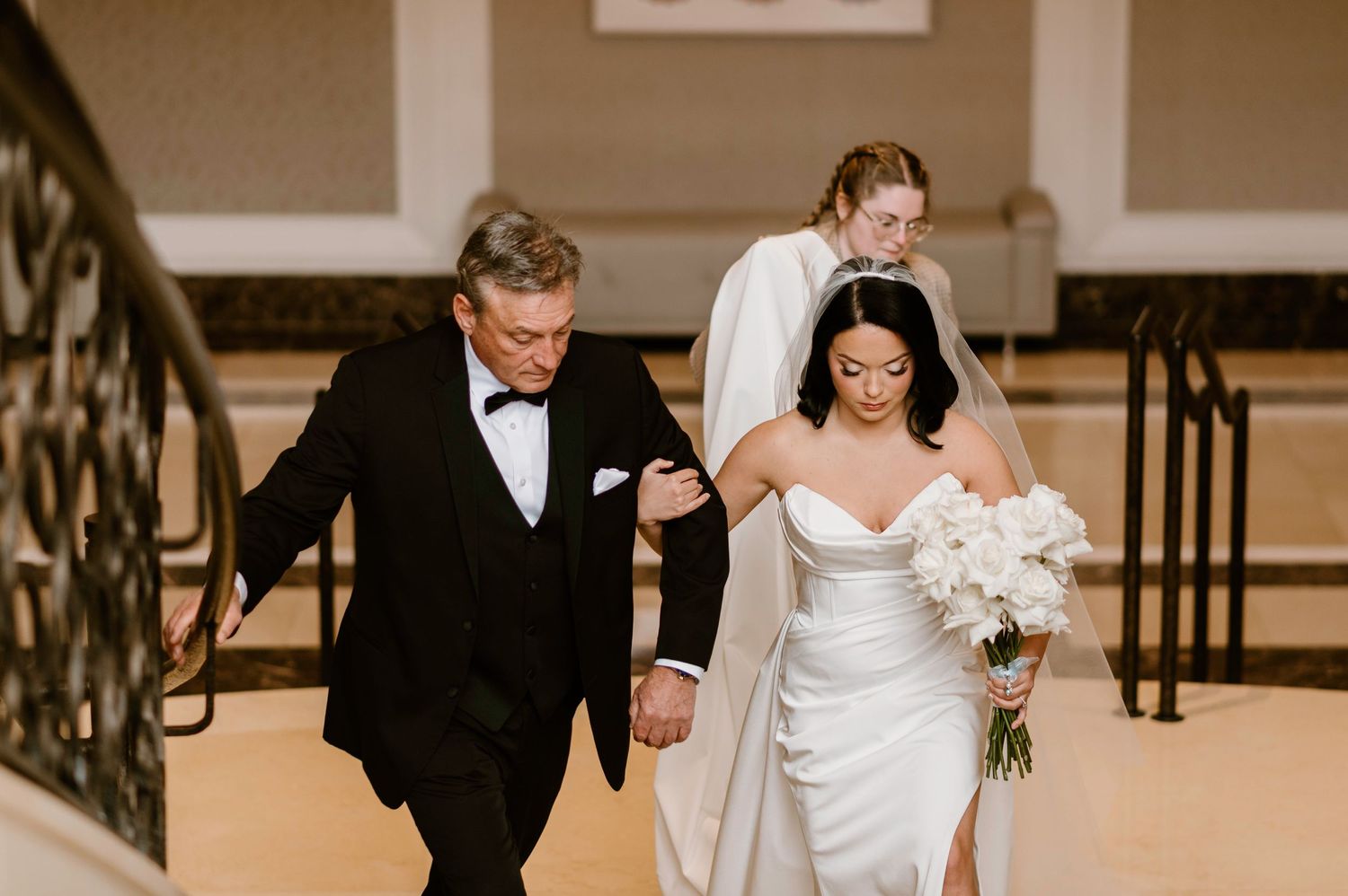 Wedding ceremony processional in elegant indoor venue with classic decor.