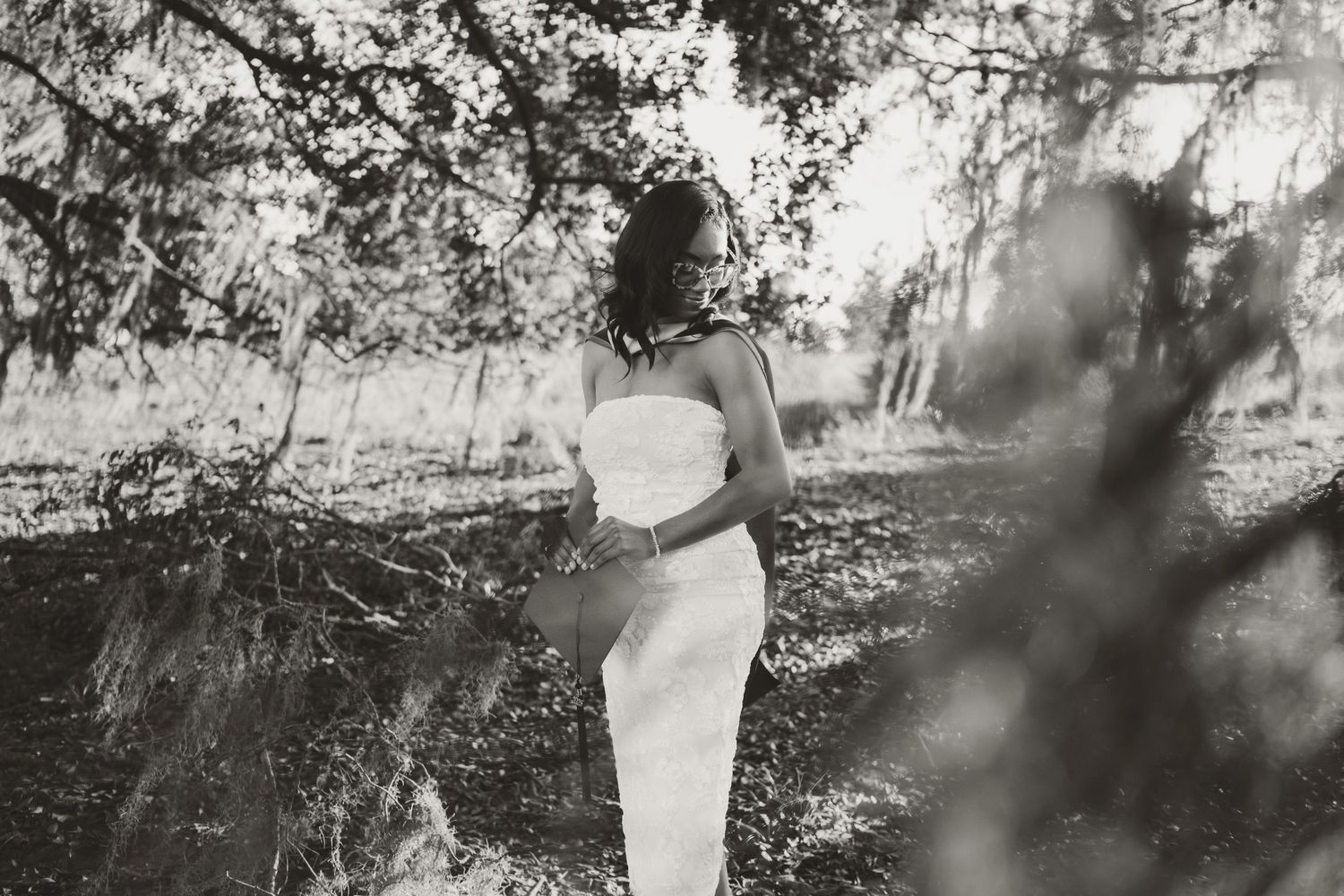 A dreamy black and white portrait sequence showing movement under tree branches.