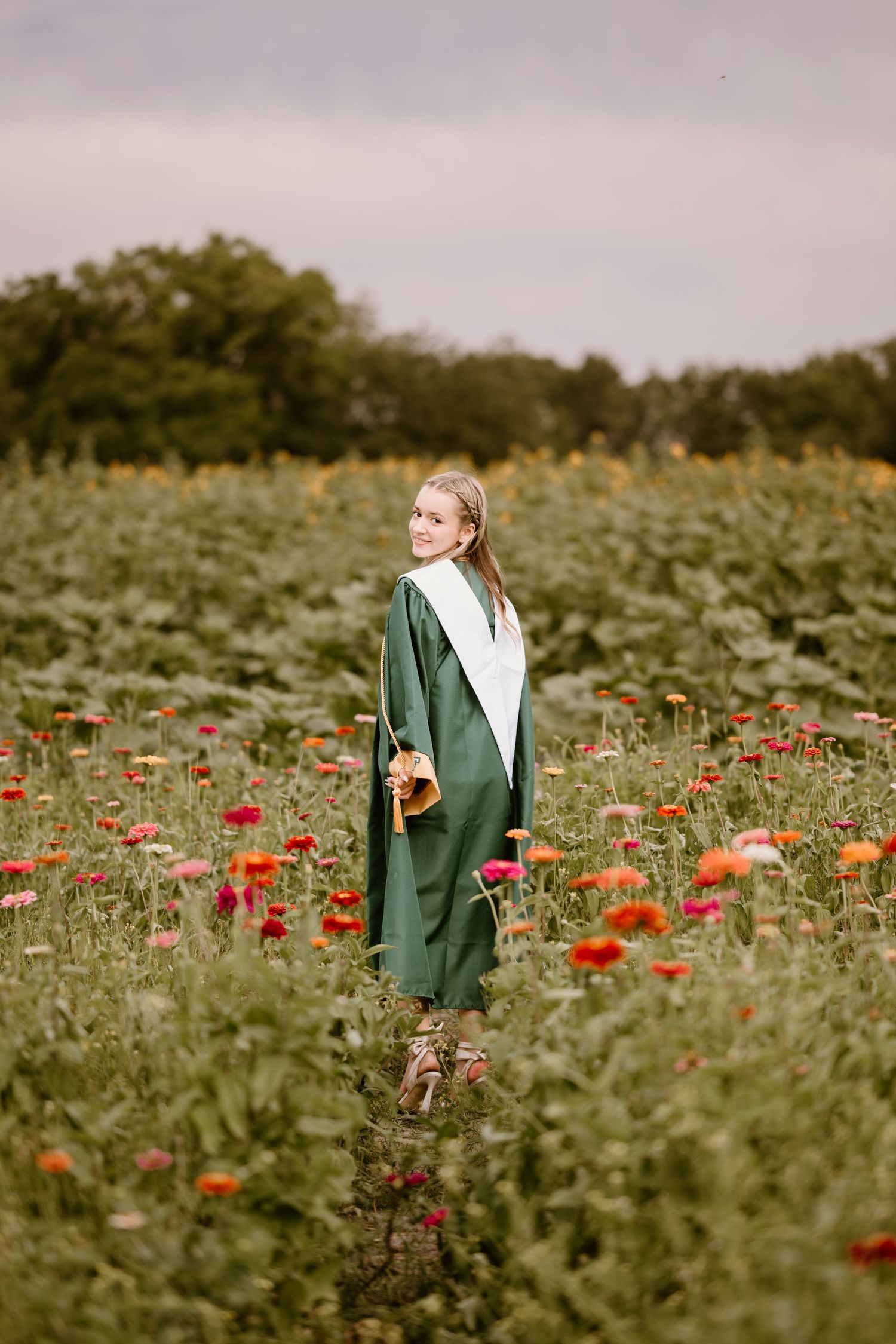 A scenic graduation photo with red poppies stretching across a vast field.