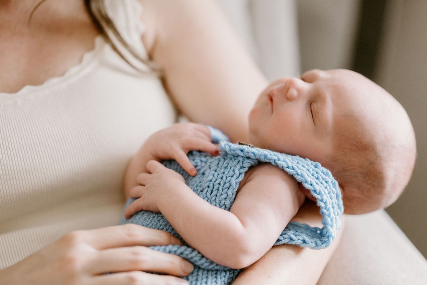 Close-up details of tiny baby feet wrapped in blue knit fabric.