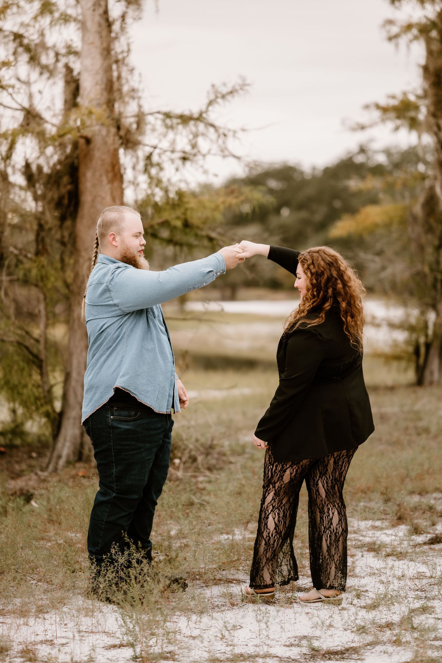 A couple shares playful moments together in a natural outdoor setting.