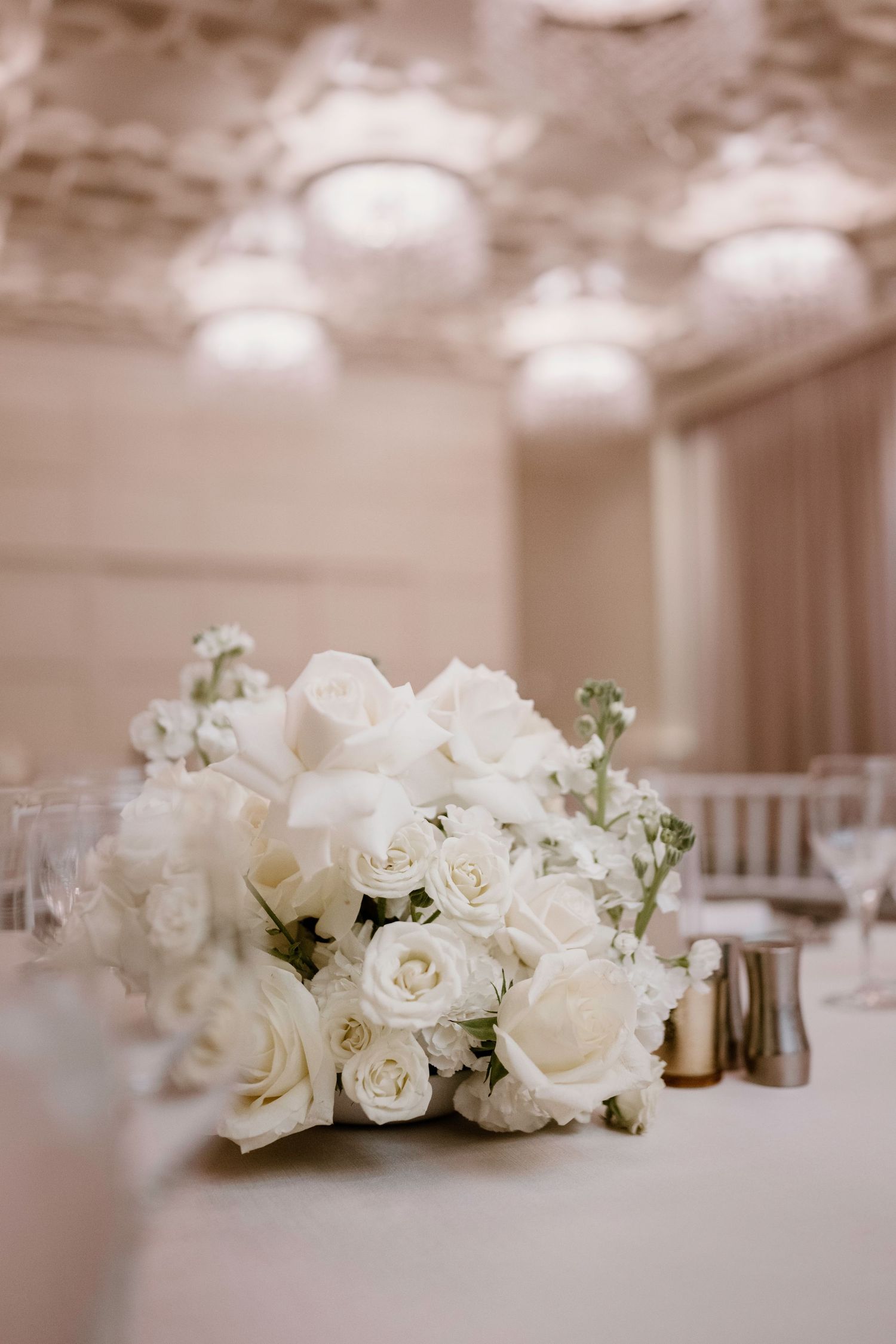 White rose centerpiece arrangement on wedding reception table.