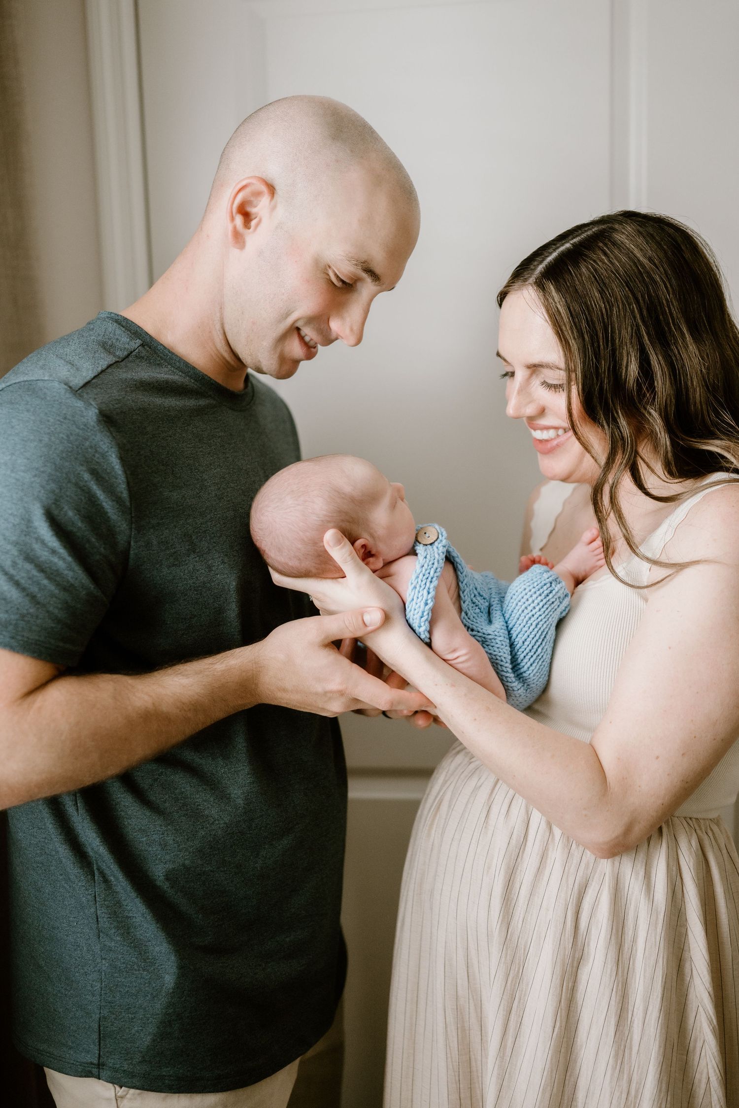 Series of candid moments between parents and their newborn baby in casual home setting.