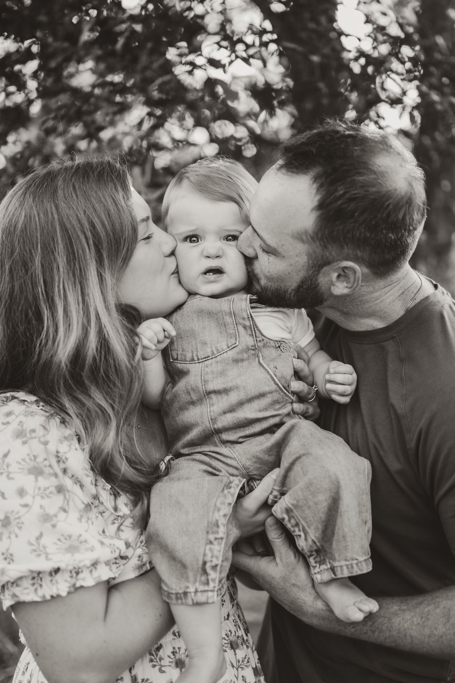 A tender family moment captured in black and white under natural lighting.