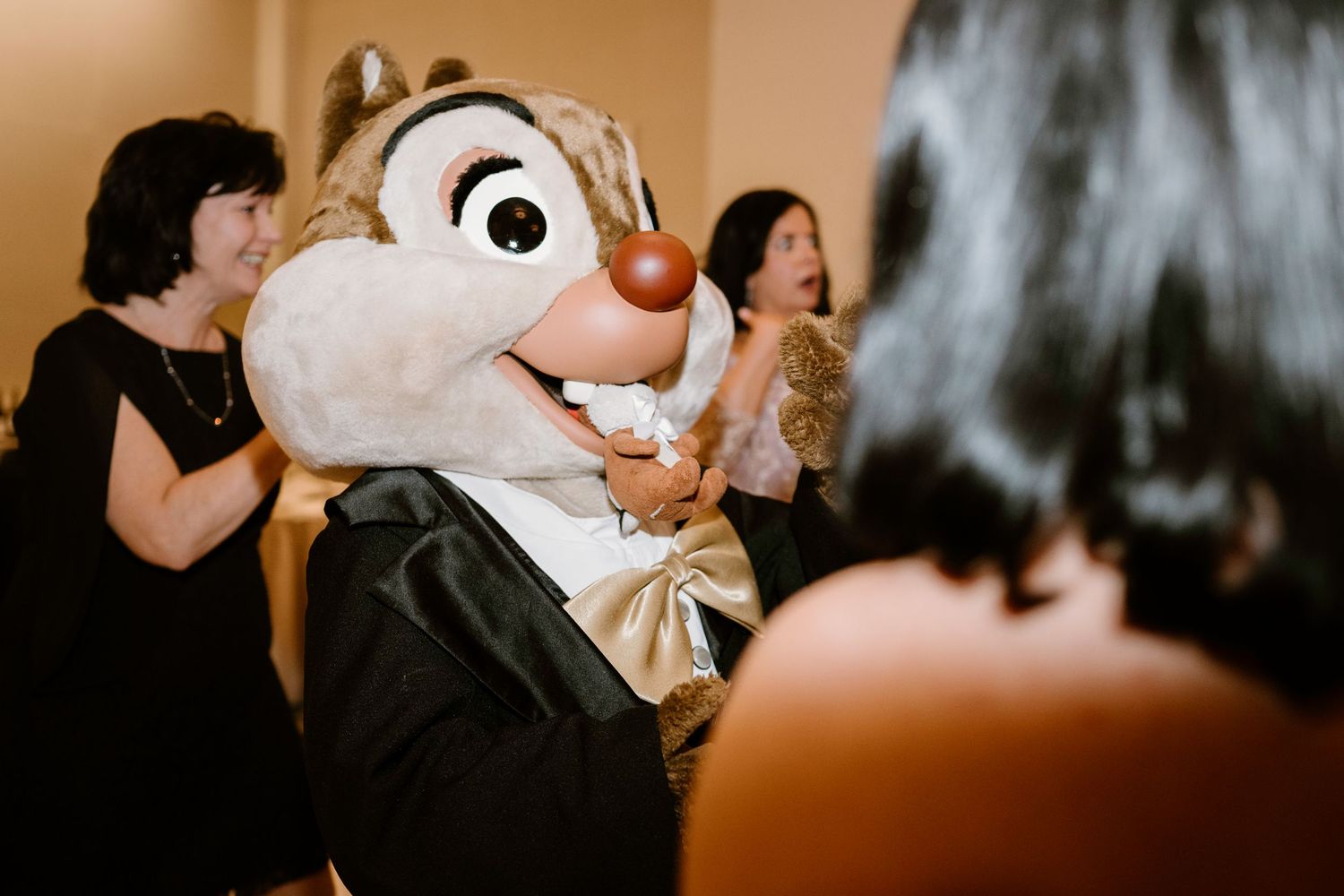Close-up of Disney character mascot with large eyes and red nose at wedding reception.