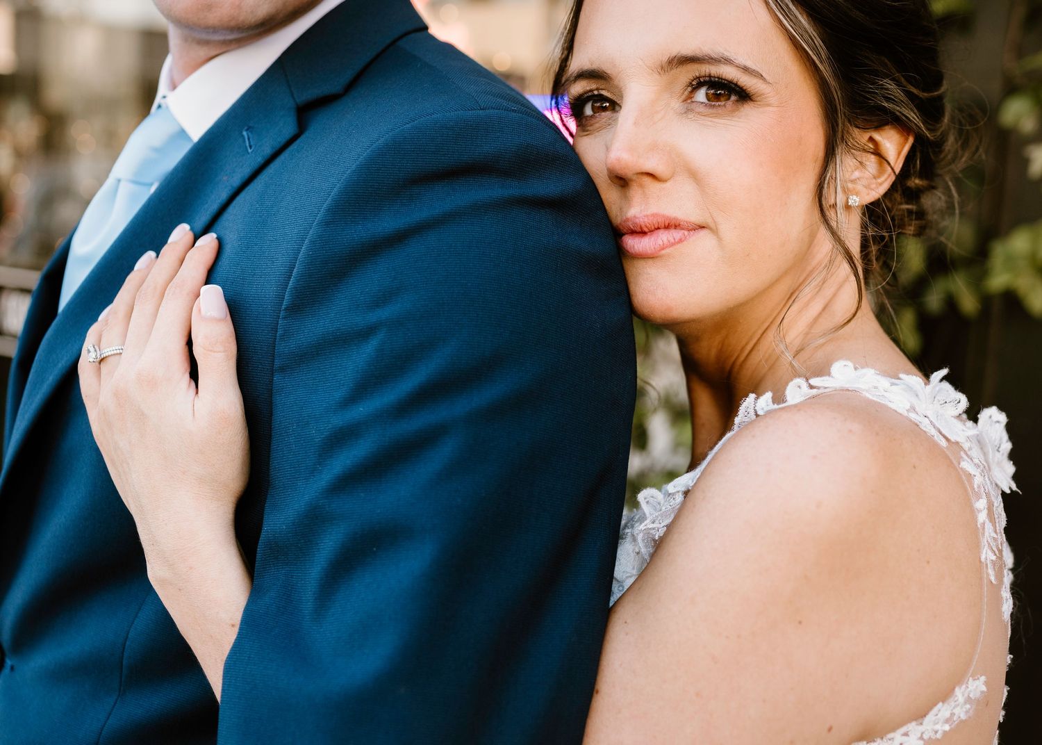 Close-up wedding portraits showing intimate moments in navy and white attire.