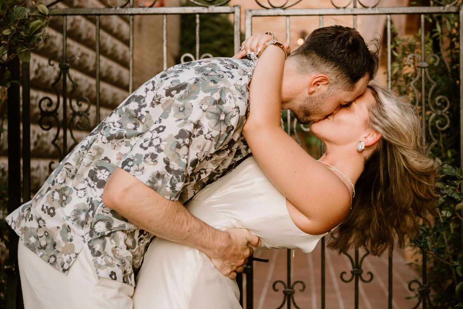 A couple embraces during a romantic engagement photo session outdoors.