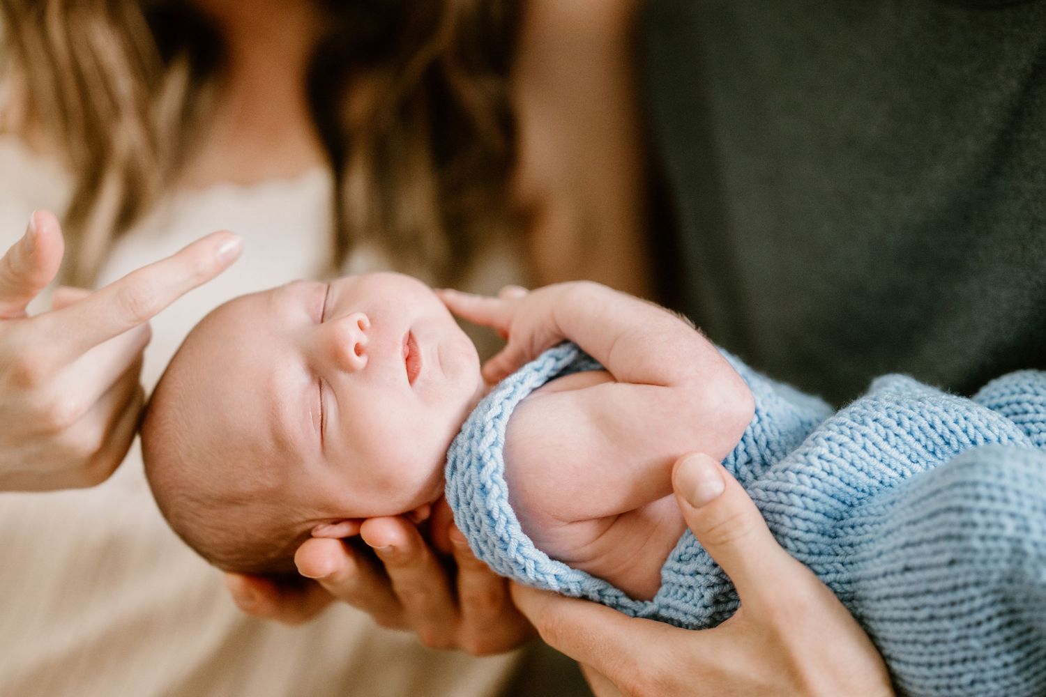 Sweet moment of a sleeping newborn being held with gentle care.