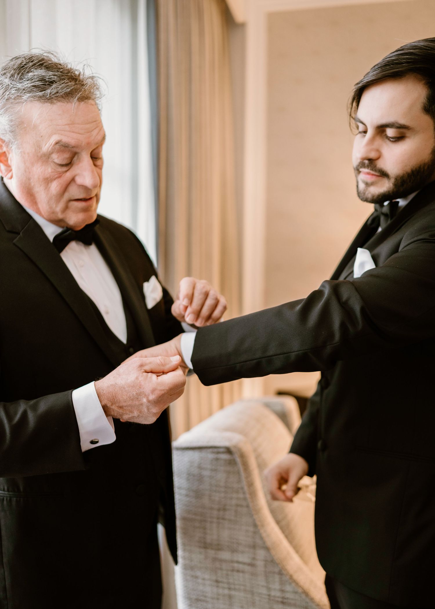 Men in tuxedos share playful fist bump sequence at wedding.
