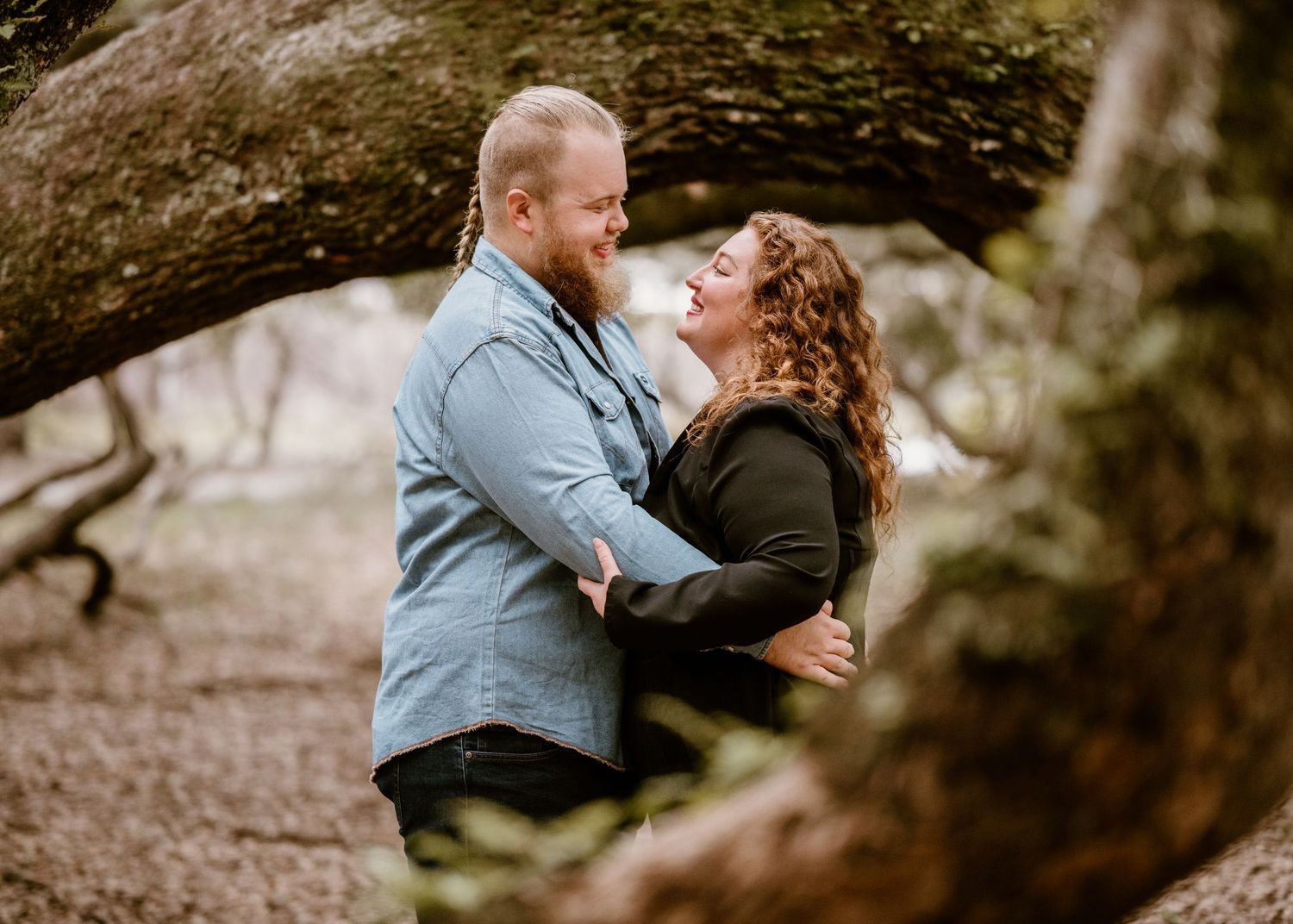 Intimate couple photos taken under sprawling tree branches.