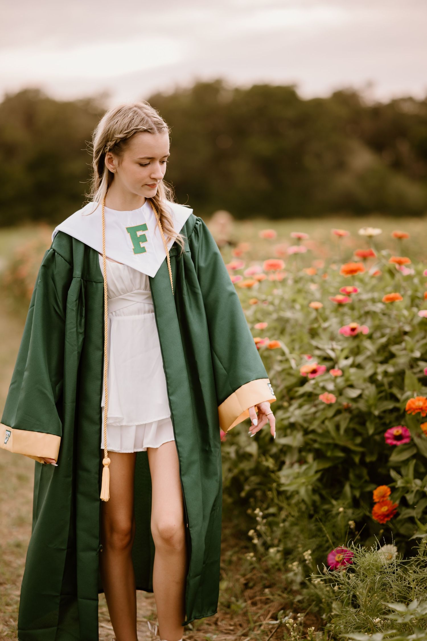 A graduation photo series in a wildflower field with red and orange blooms.