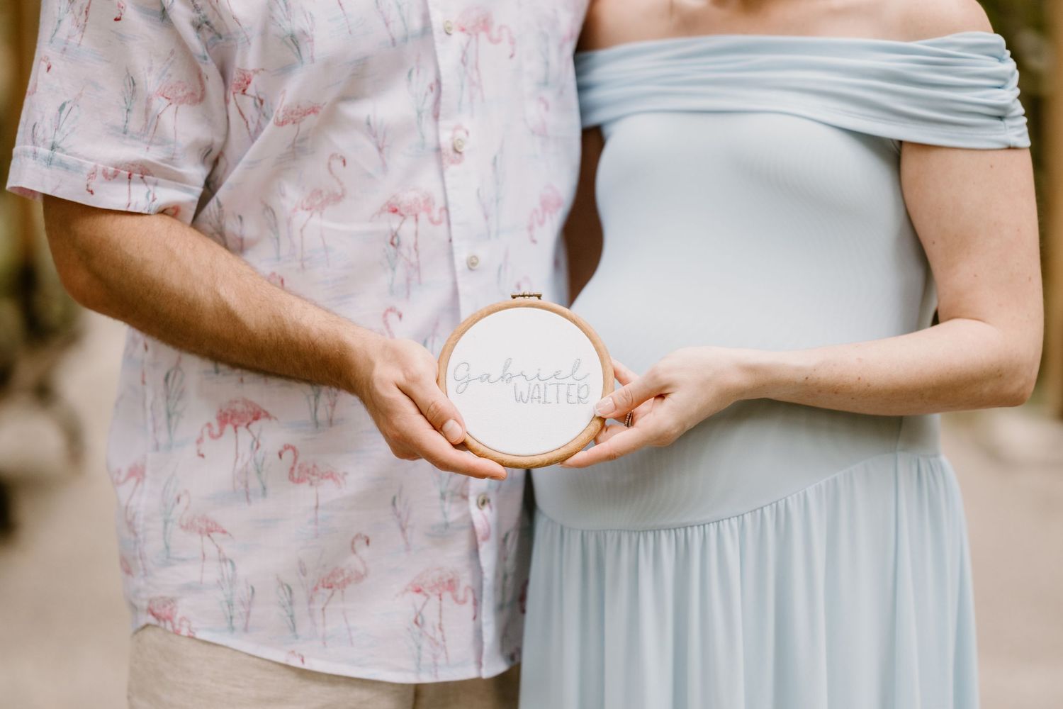 Couple in soft pastel outfits holding hands during an outdoor photo session.