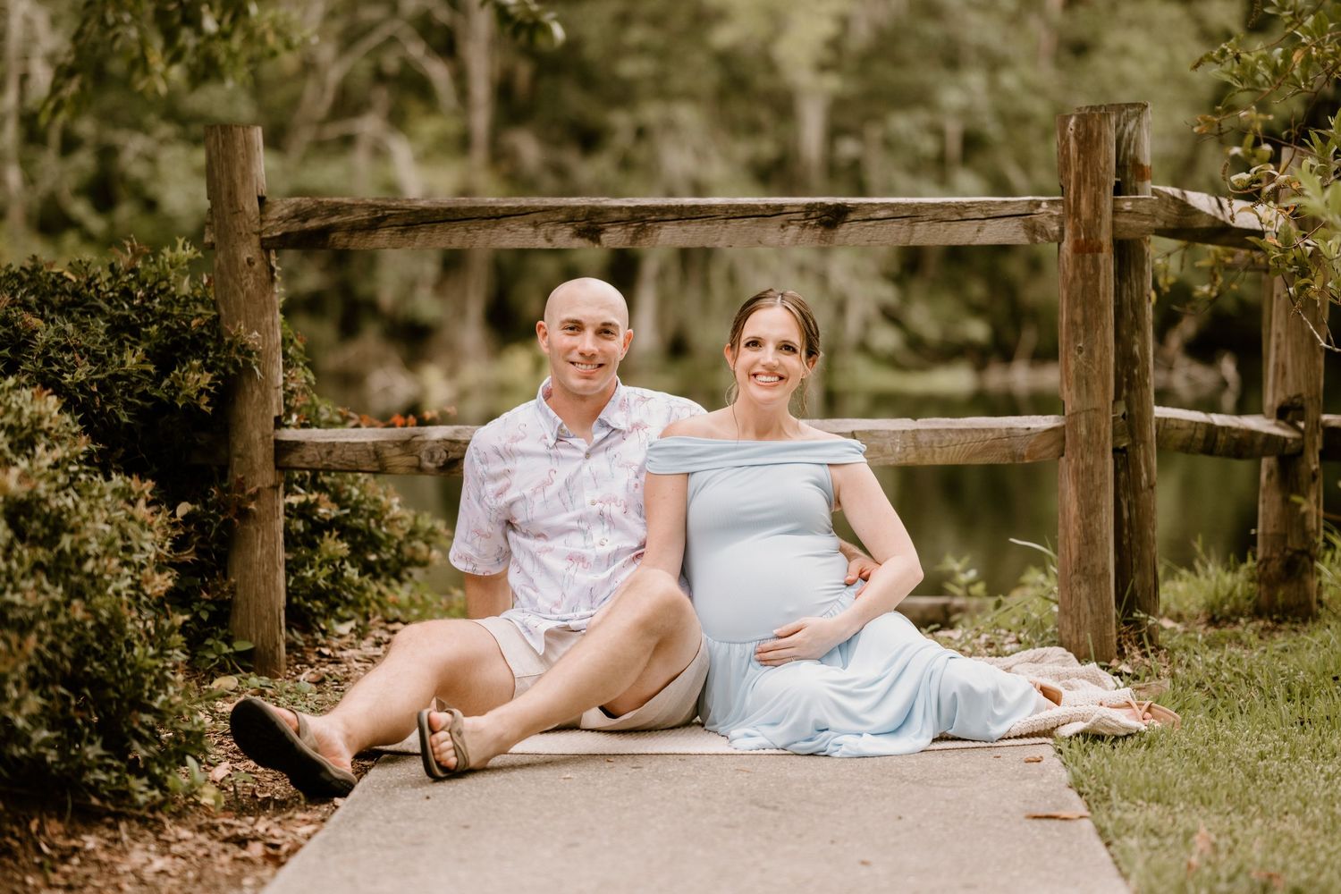 Couple lounging on rustic wooden deck in natural outdoor setting.