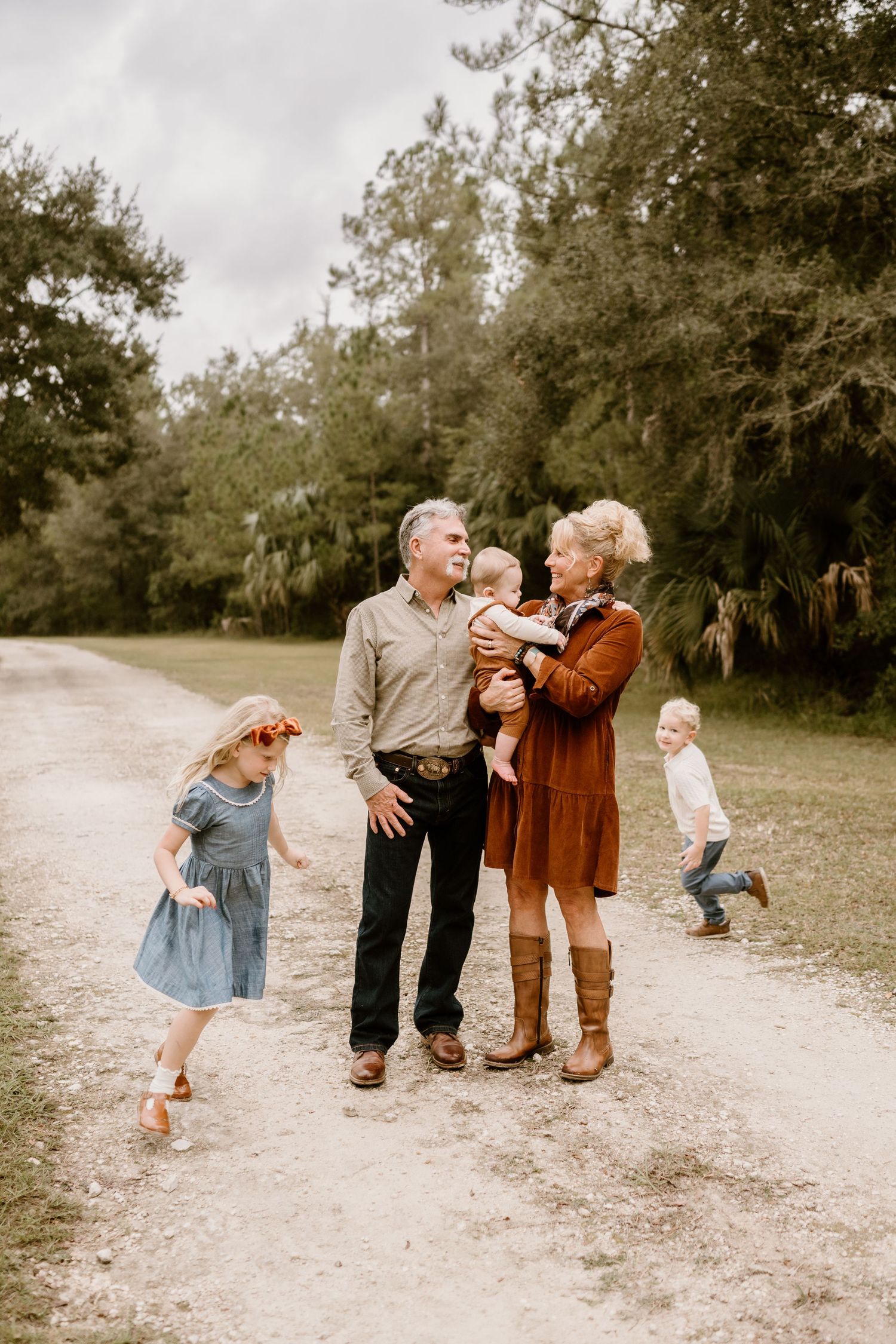 Playful family moments captured on a dirt path surrounded by trees.