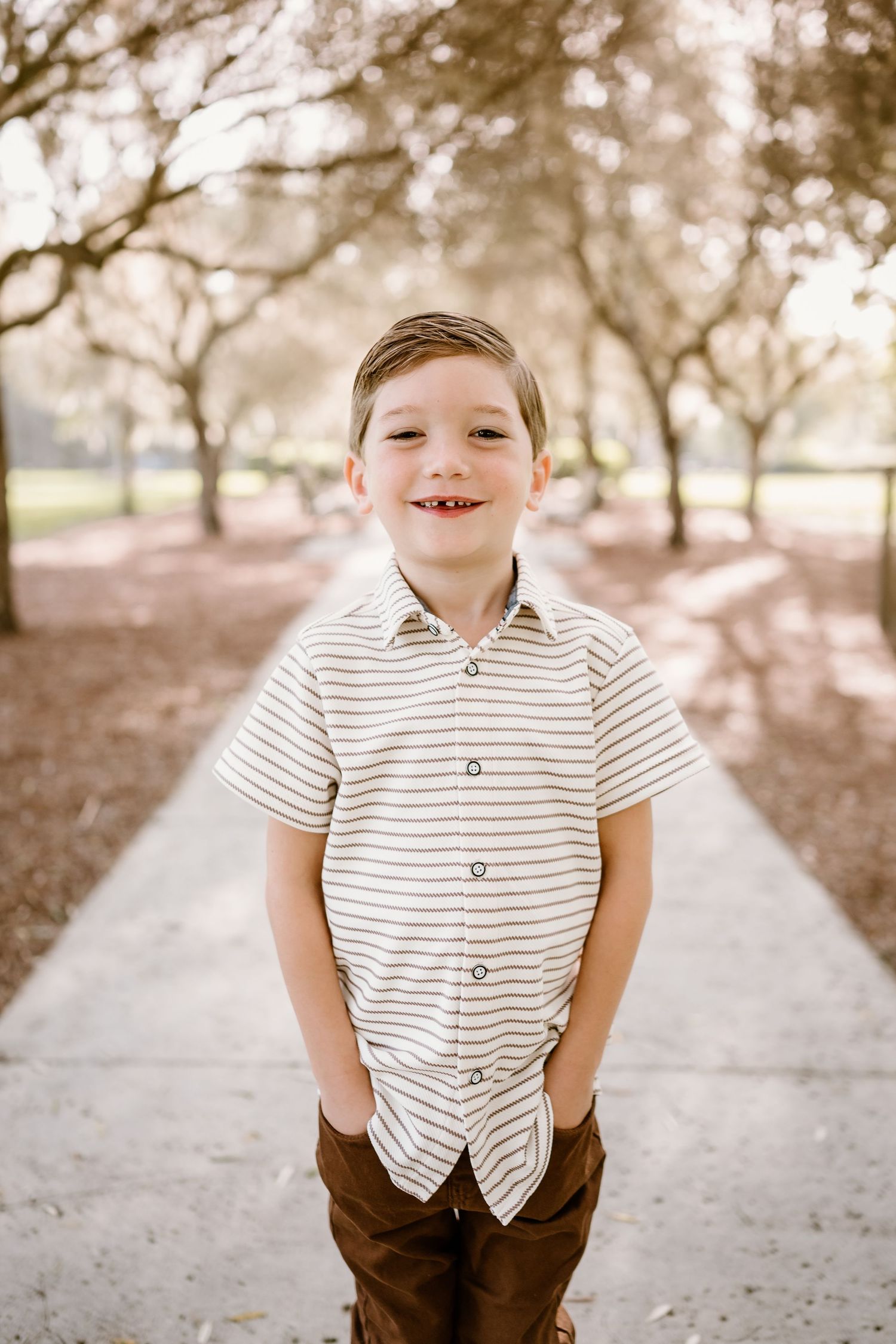 A series of playful portraits showing a young child in a striped shirt and brown pants against a soft outdoor backdrop.