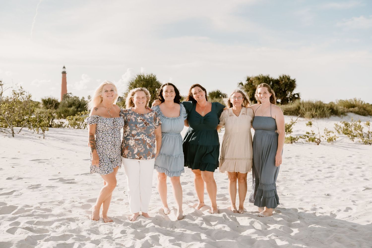 Extended family and wedding guests gather for group photos on pristine beach.