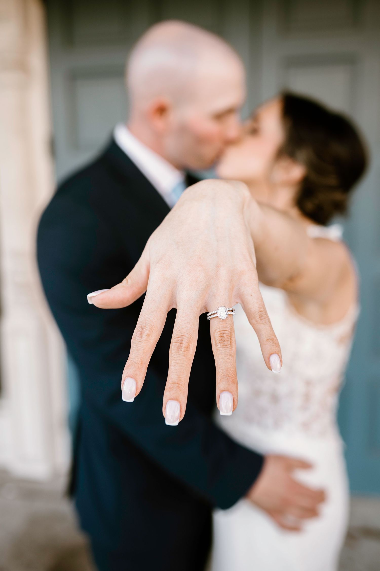 Series of detail shots showing bride's hands and engagement ring against white lace wedding dress.