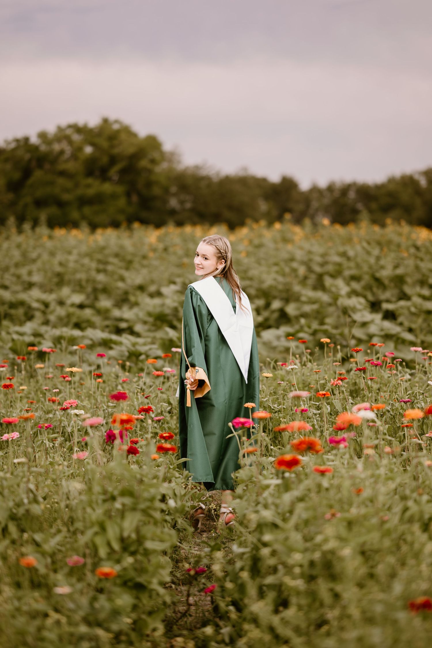 Figure walking through a vibrant field of red poppies wearing a green jacket.