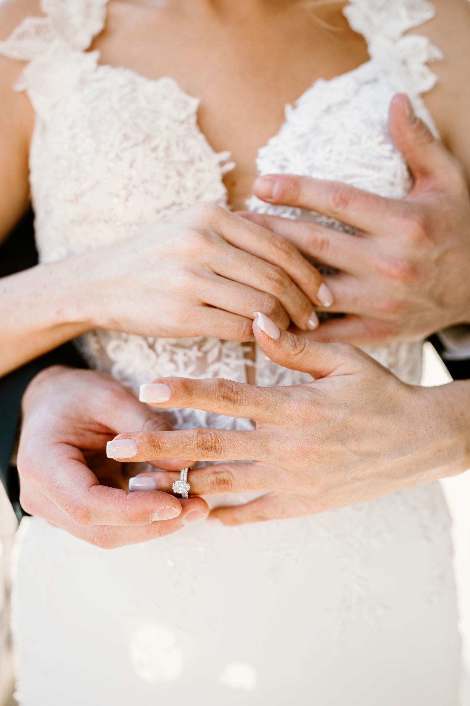 Close-up shots of hands with wedding rings and lace dress details.