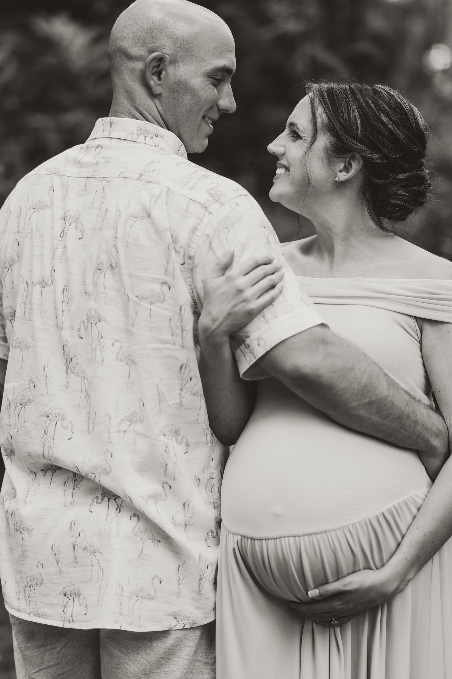 A couple shares an intimate black and white moment in formal attire.