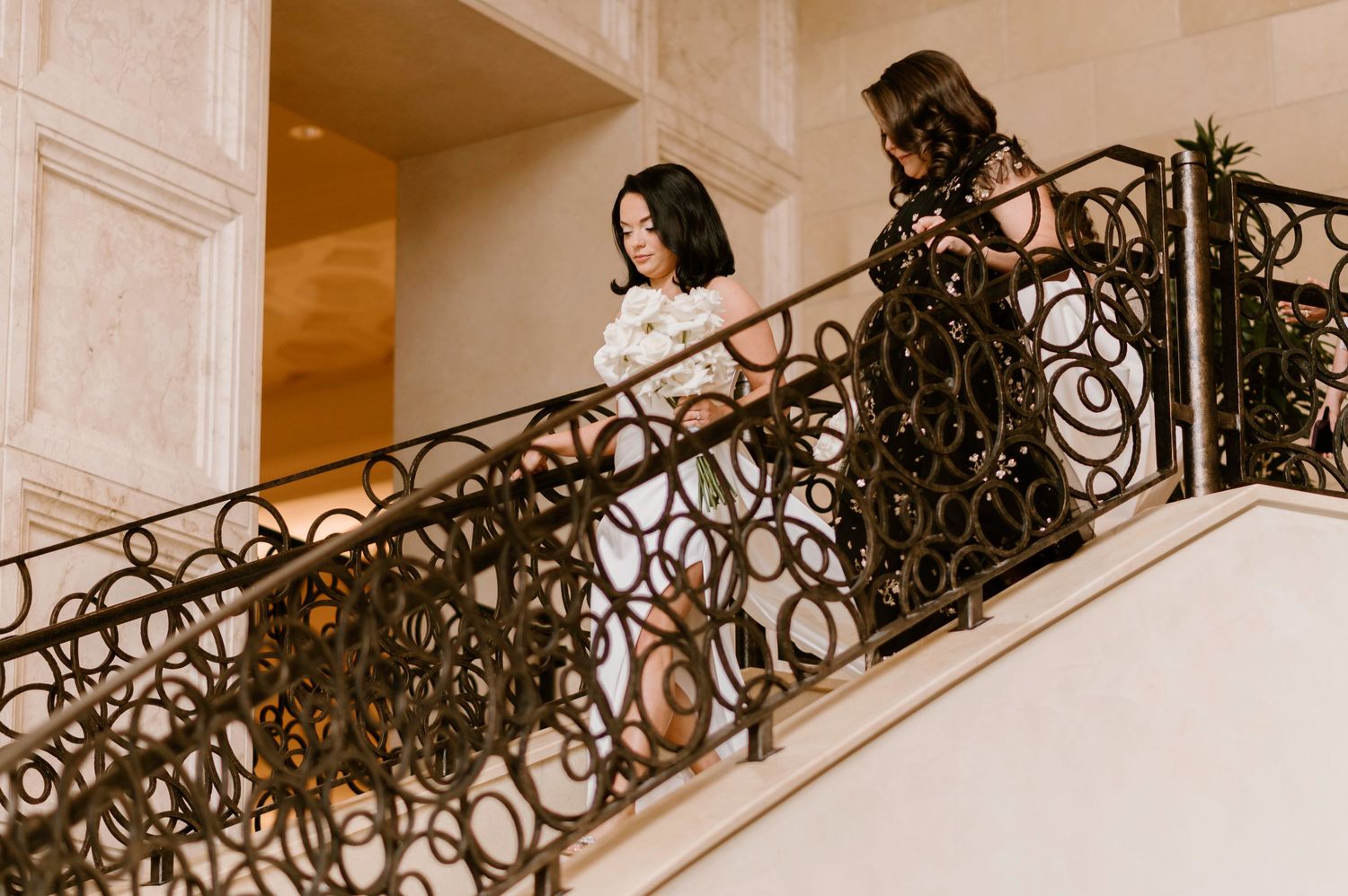 Ornate wrought iron staircase with decorative details in warm-toned interior.
