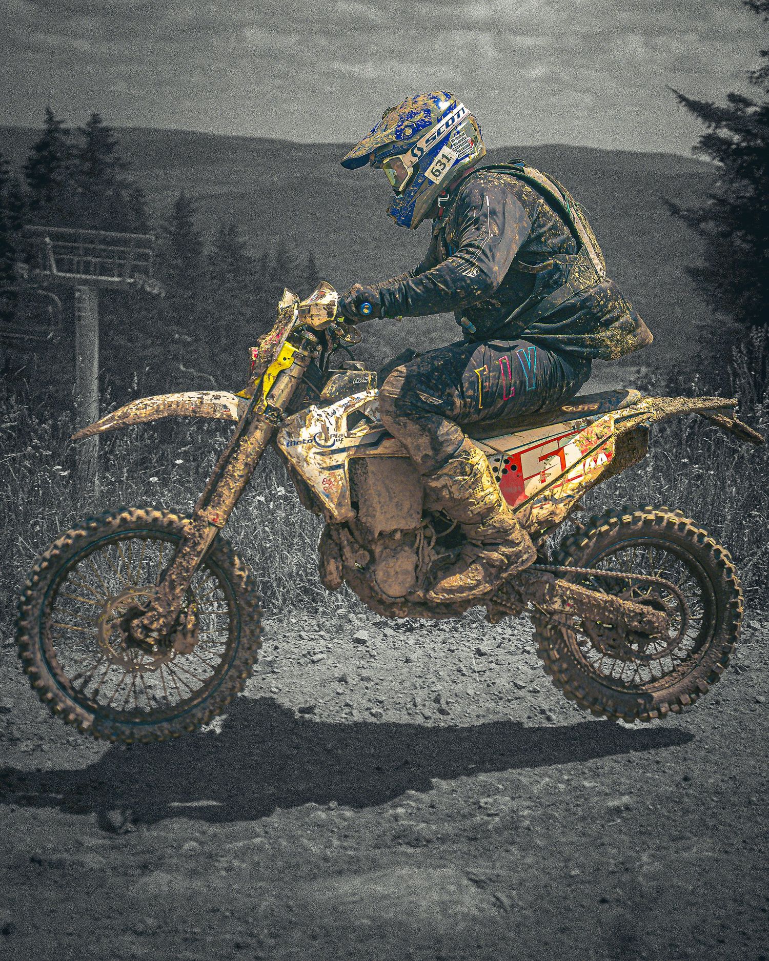 Series of muddy dirt bikes lined up showcasing their weathered and race-worn conditions.