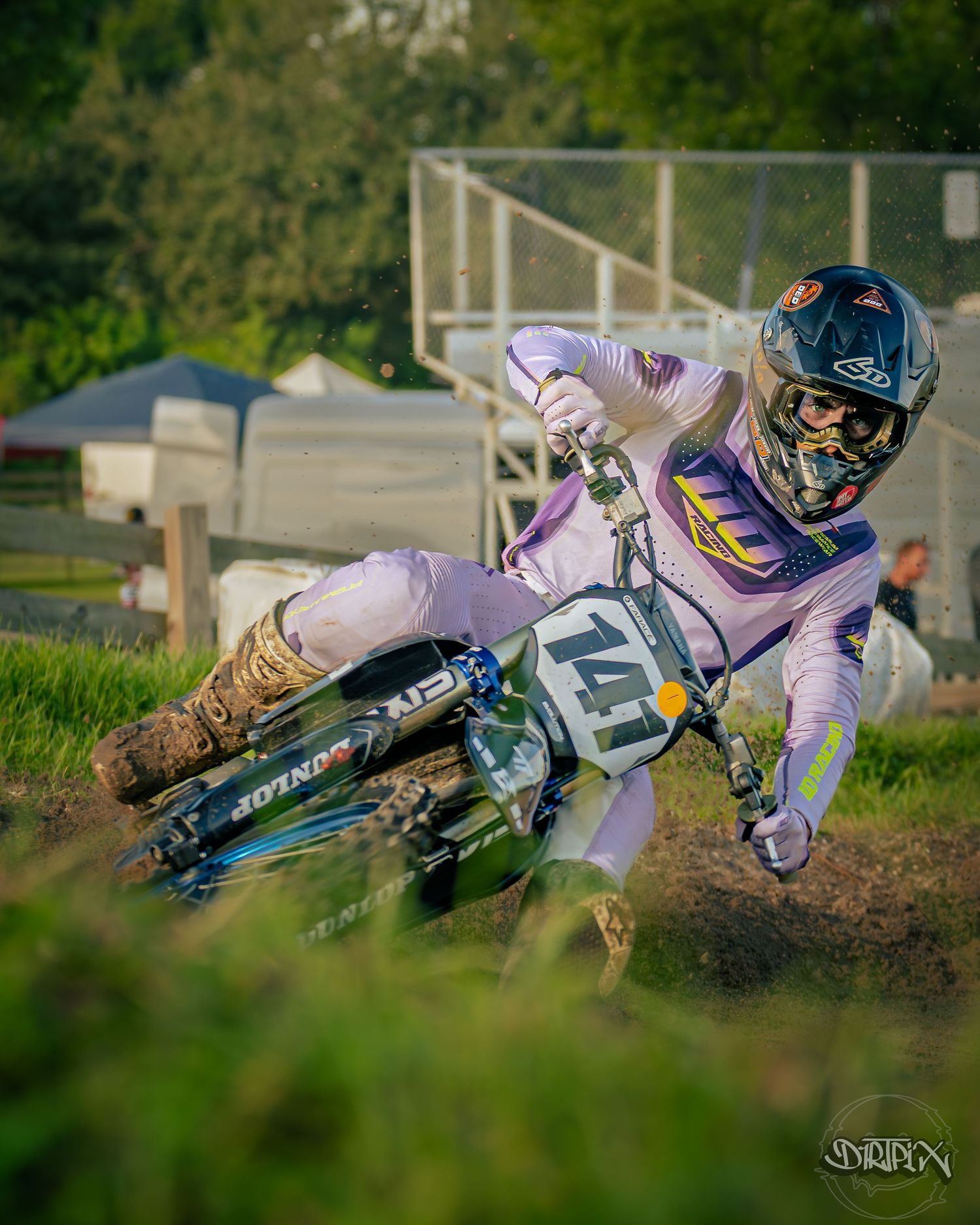 Multiple riders lean into a banked turn during intense motocross competition.