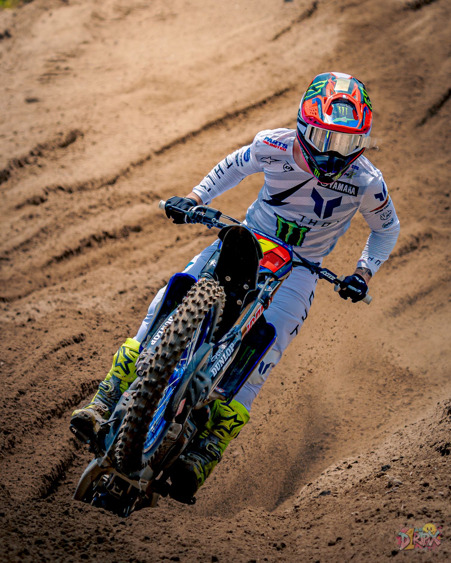 Time lapse sequence of a motocross rider kicking up dirt through a corner on dirt track.