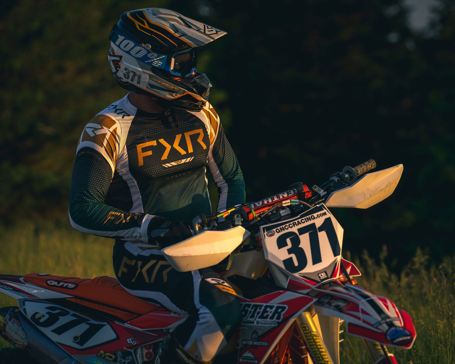Motorcycle rider silhouetted against dark background during evening ride.