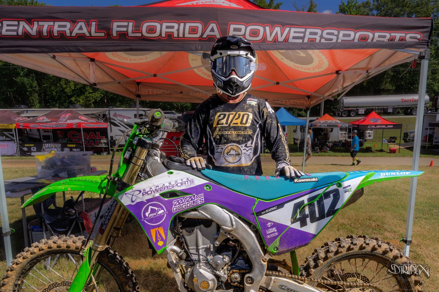 Colorful race paddock setup at Central Florida Powersports event with tents and motorcycles.