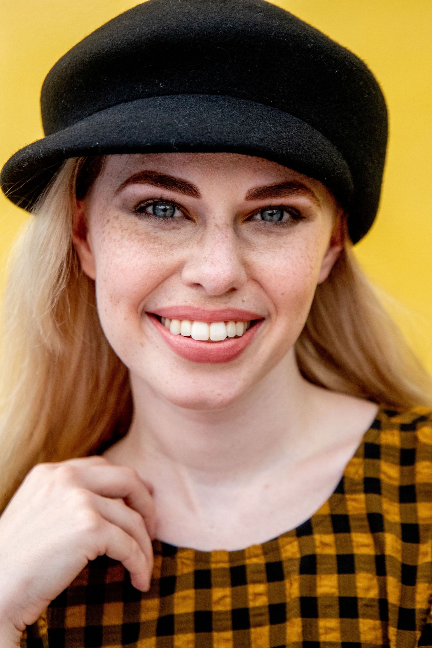 Close-up portrait series against bright yellow background featuring black cap.
