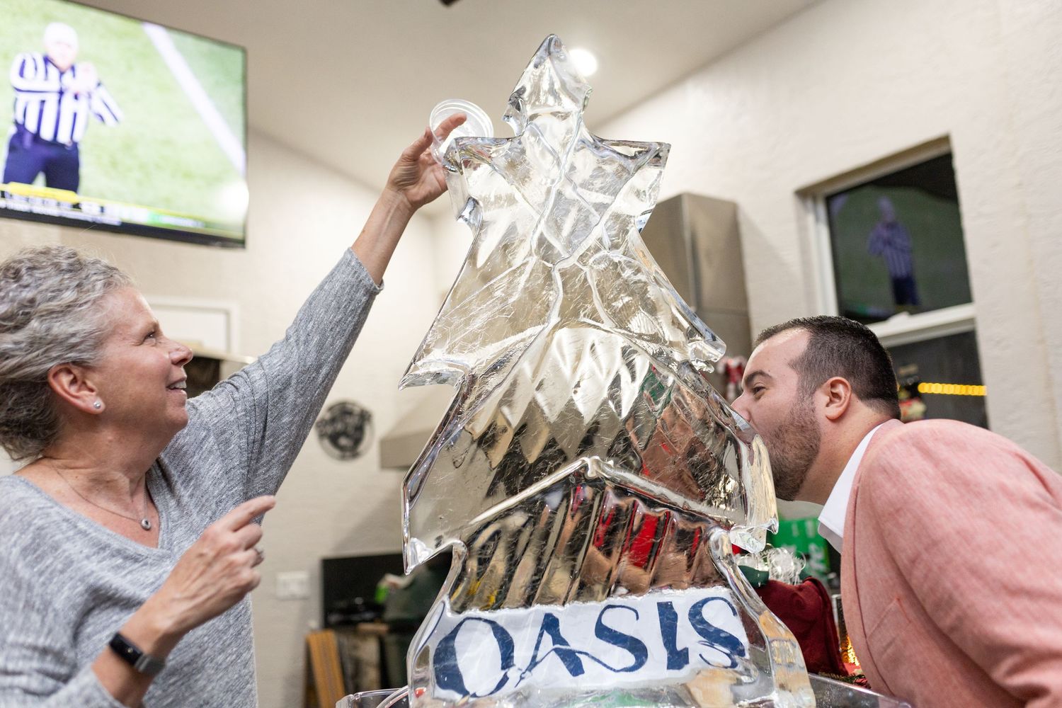 People holding up a large crystal-like decorative object in an indoor setting.