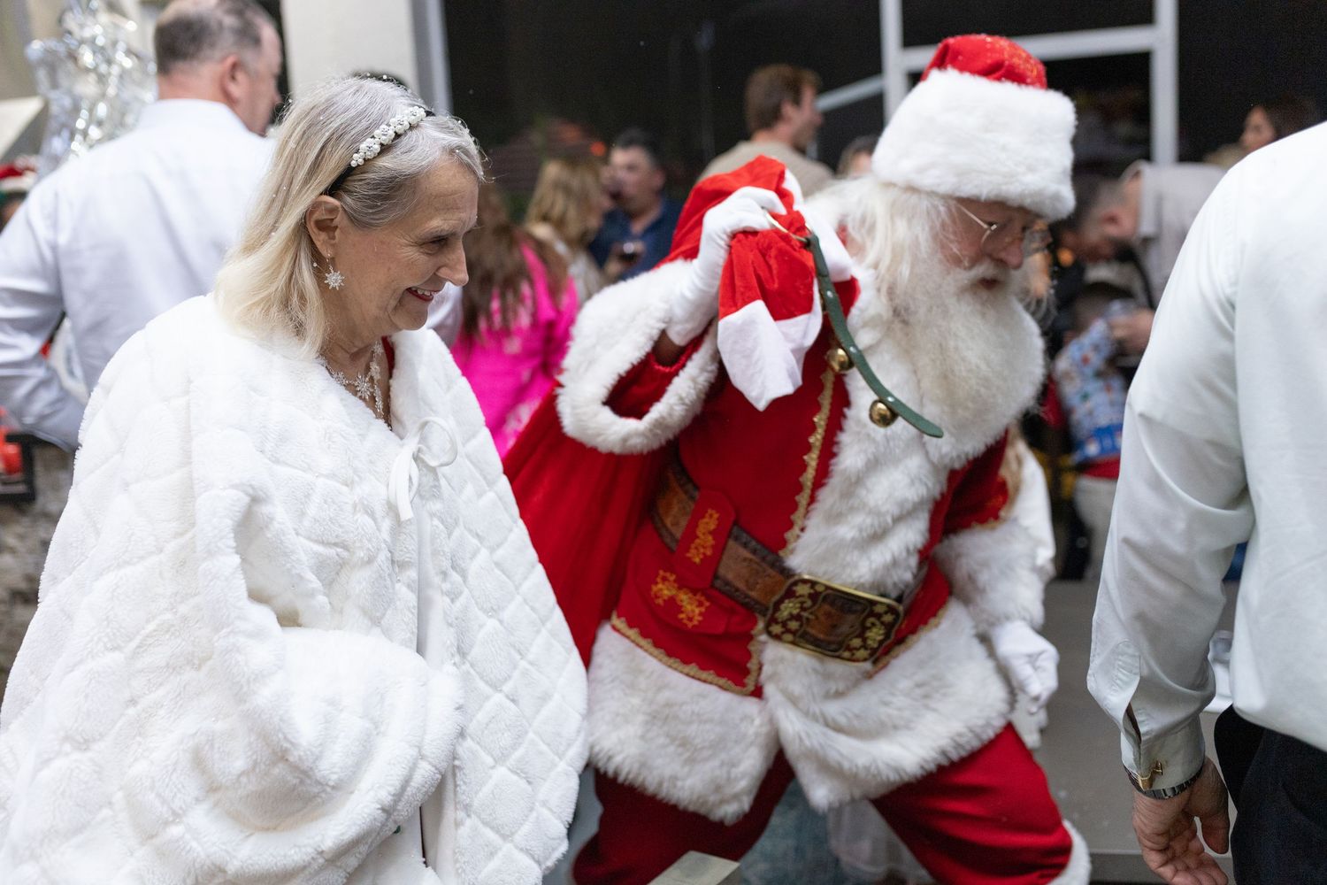 People dancing and celebrating at a festive holiday party with decorations.