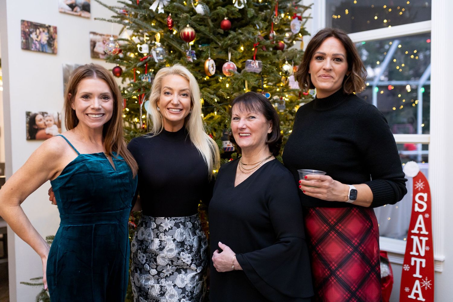 Friends gathered for holiday photos in front of a beautifully lit Christmas tree.