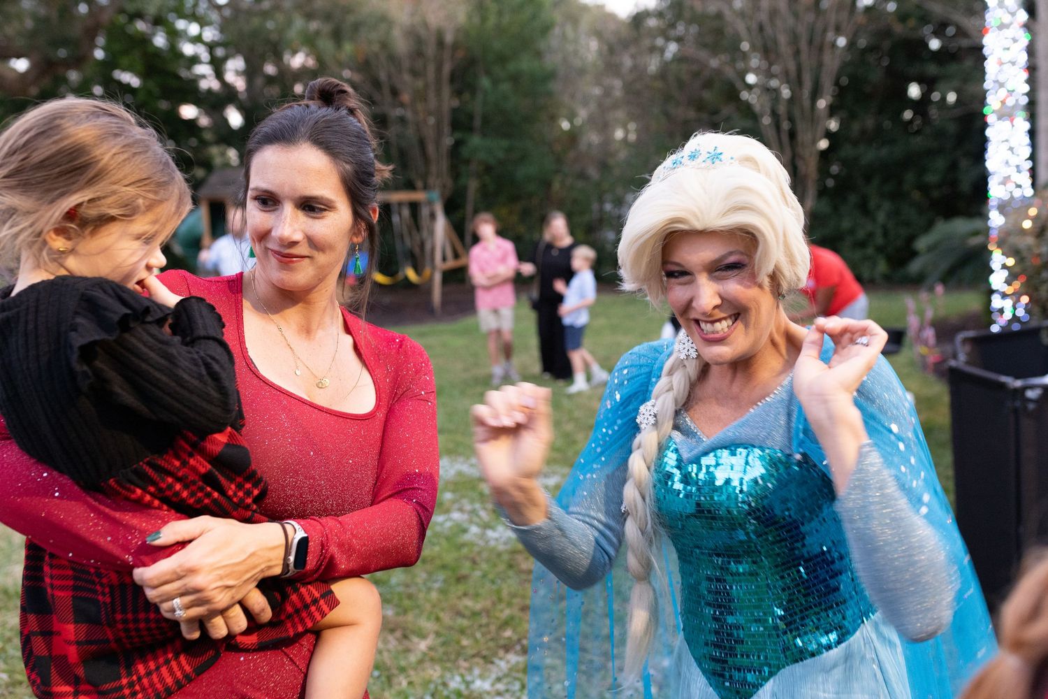 People interact with a costumed character at an outdoor winter event.