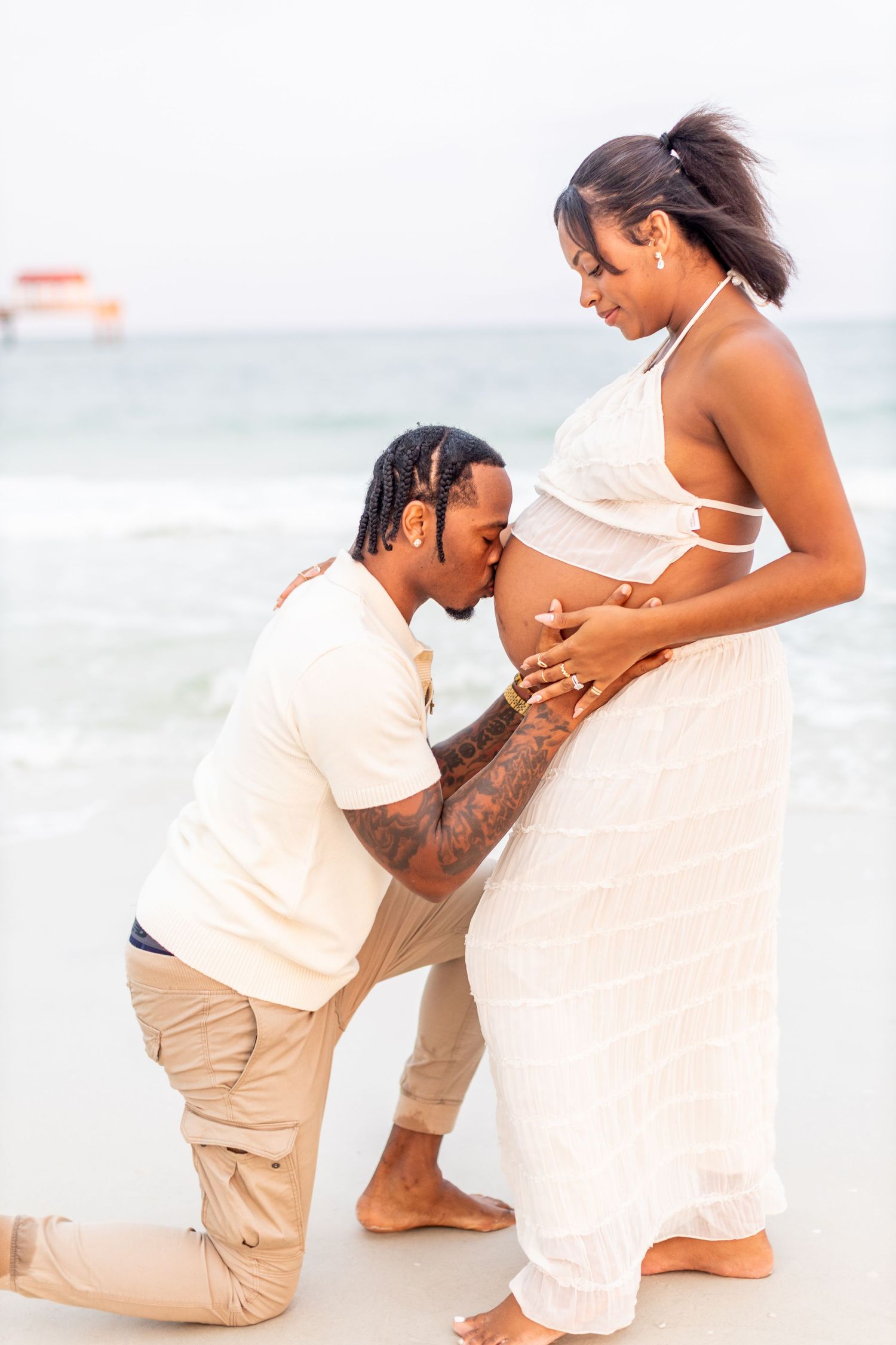 A tender maternity moment captured on the beach as a couple celebrates their pregnancy.